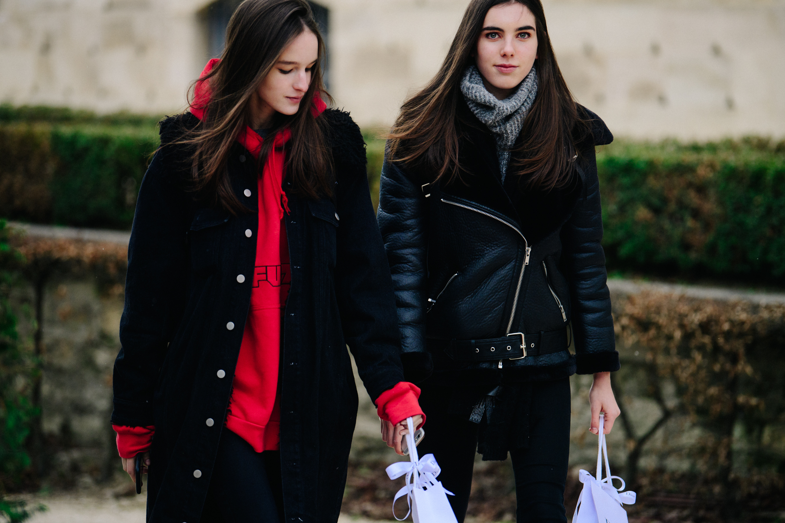 Two models wearing black coats
