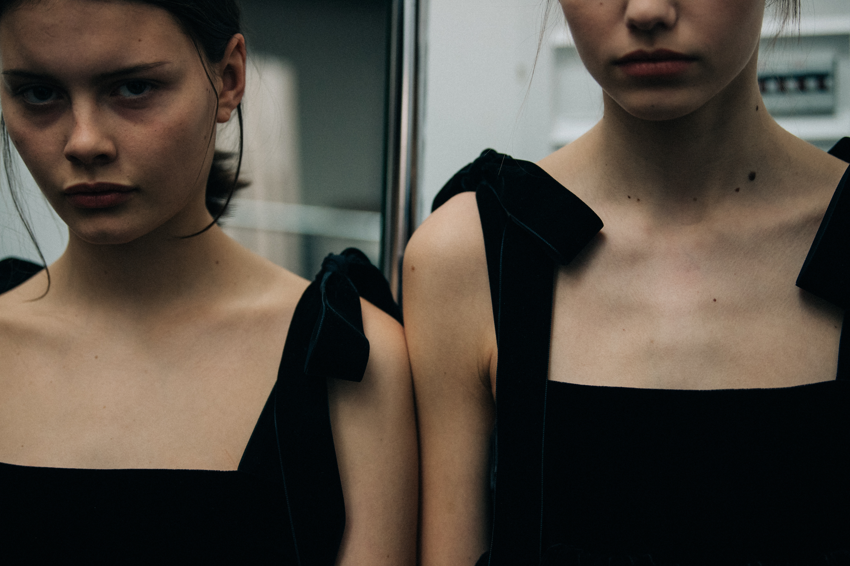 Two models wearing black dresses