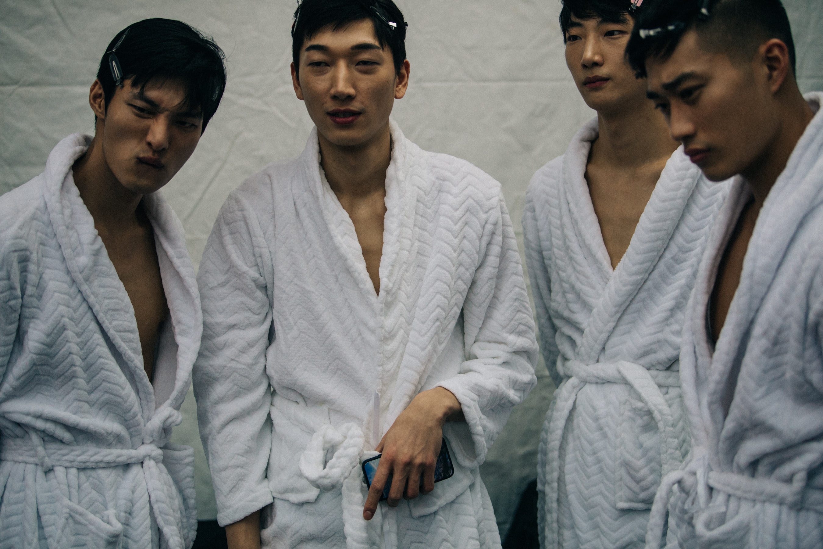 Models backstage wearing white robes