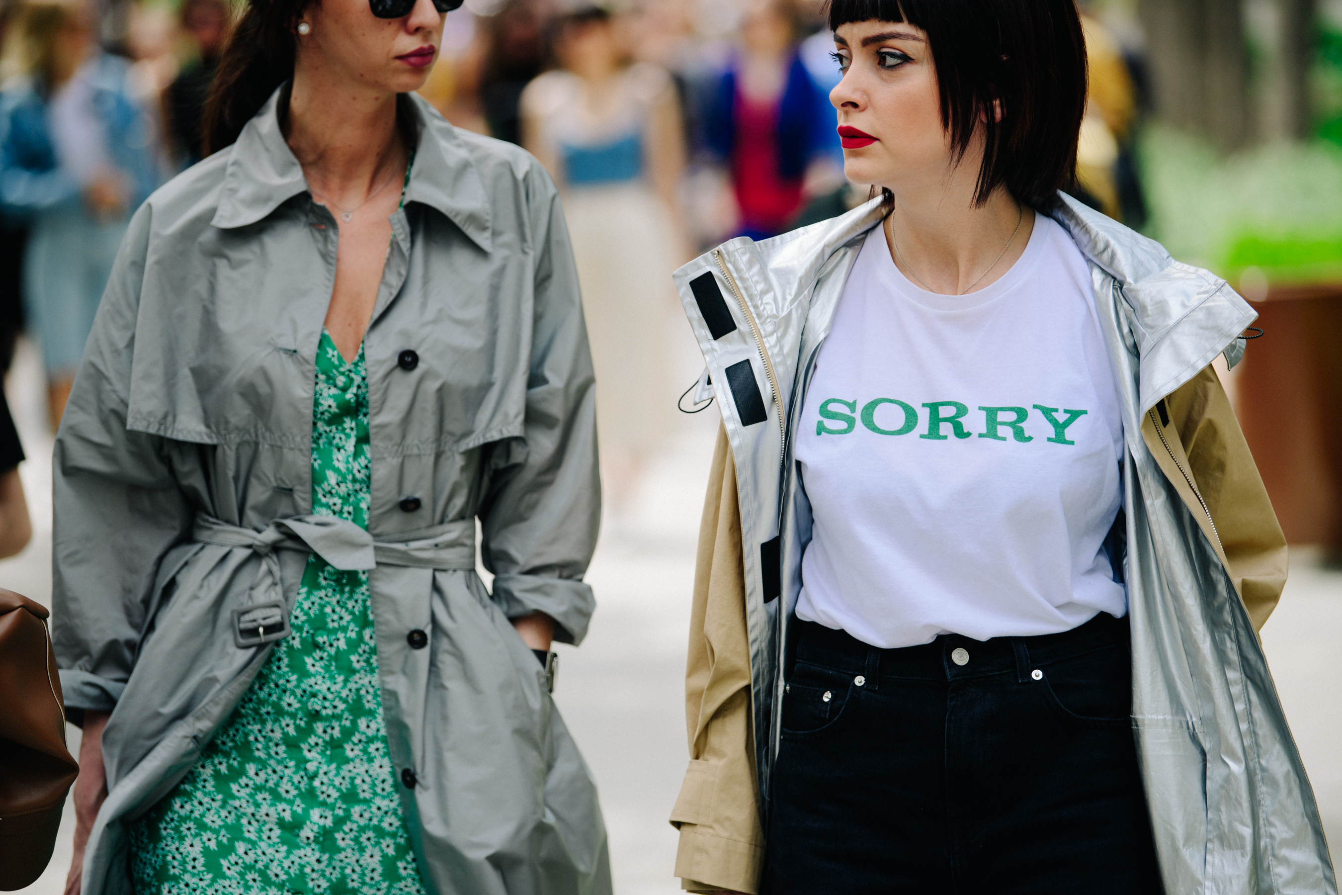 Two women wearing light coats