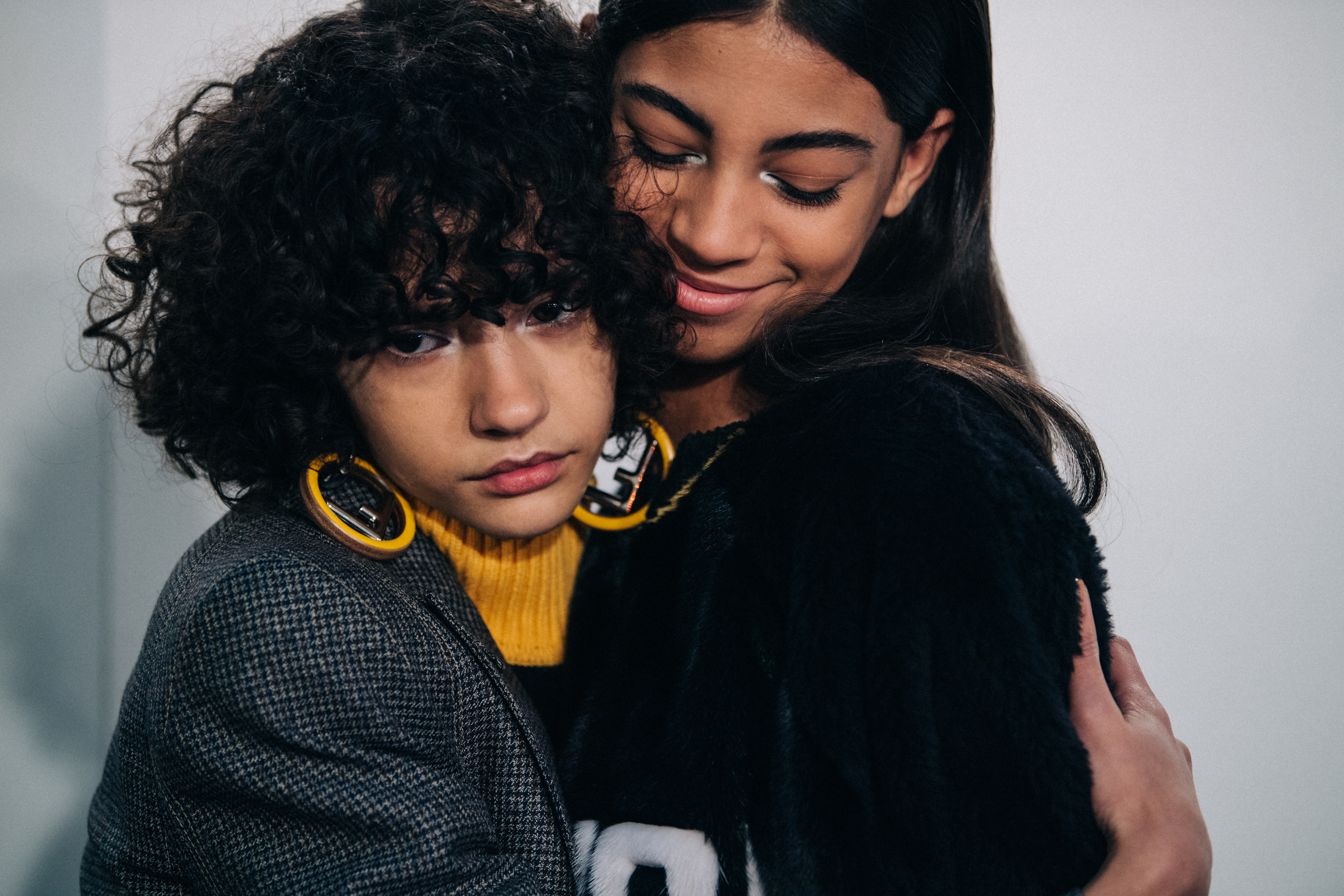 Two models wearing black Fendi jumpers