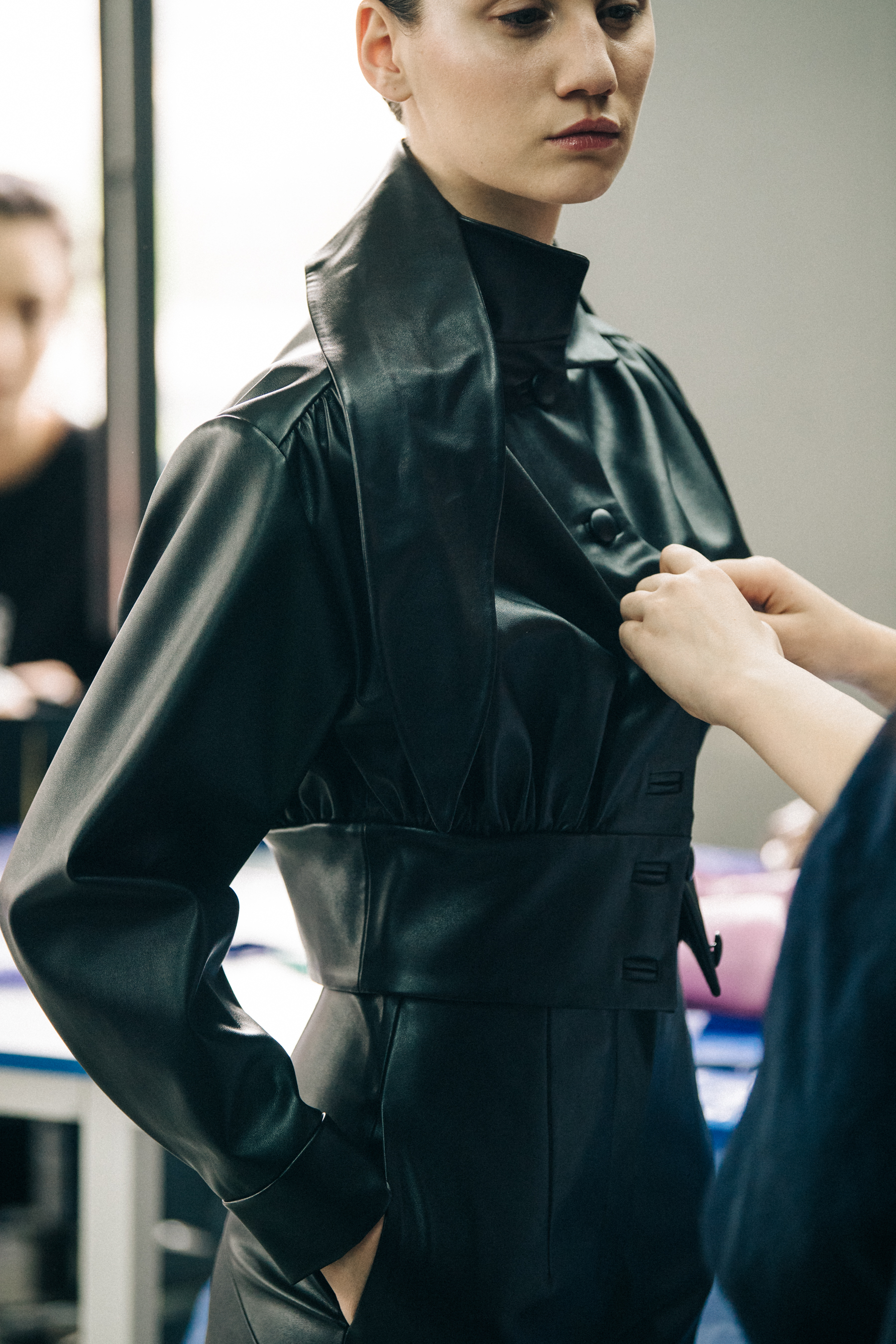 Model wearing leather coat backstage