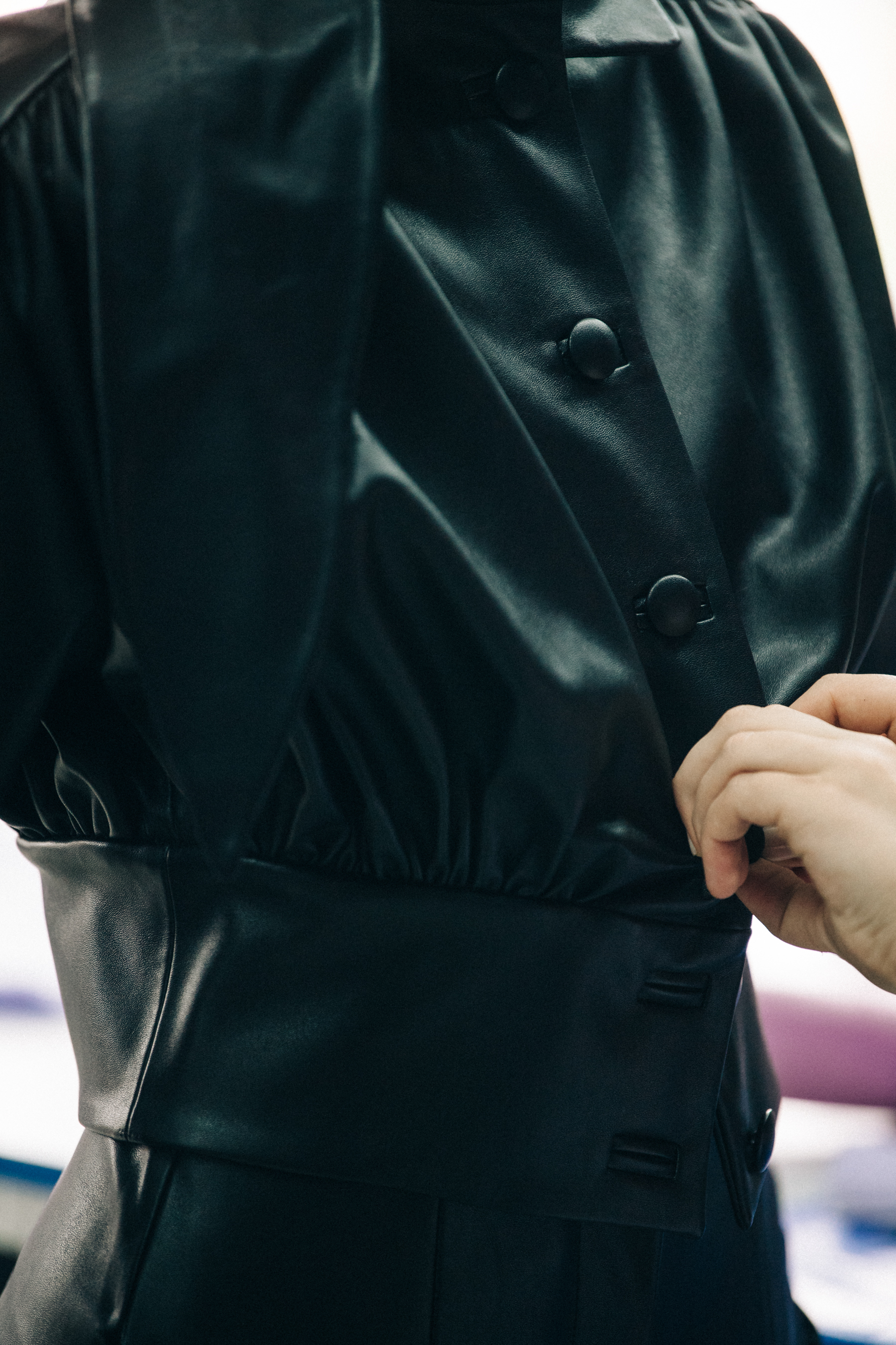 Model wearing leather coat backstage