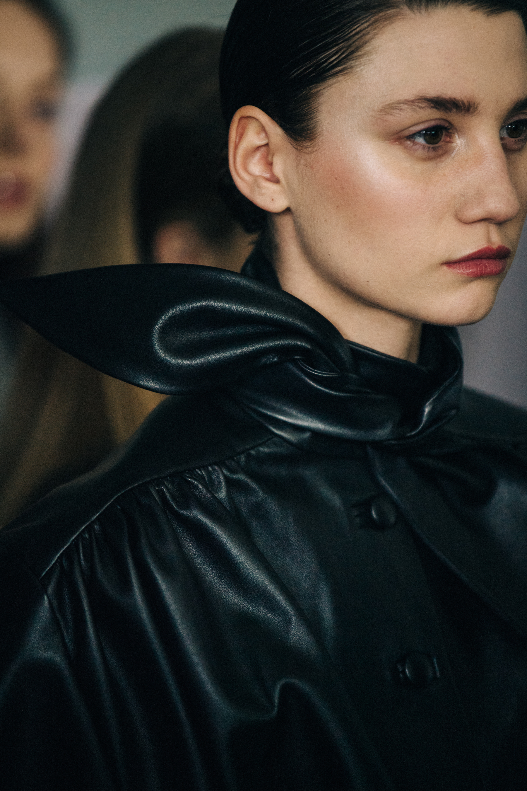 Model wearing leather coat backstage