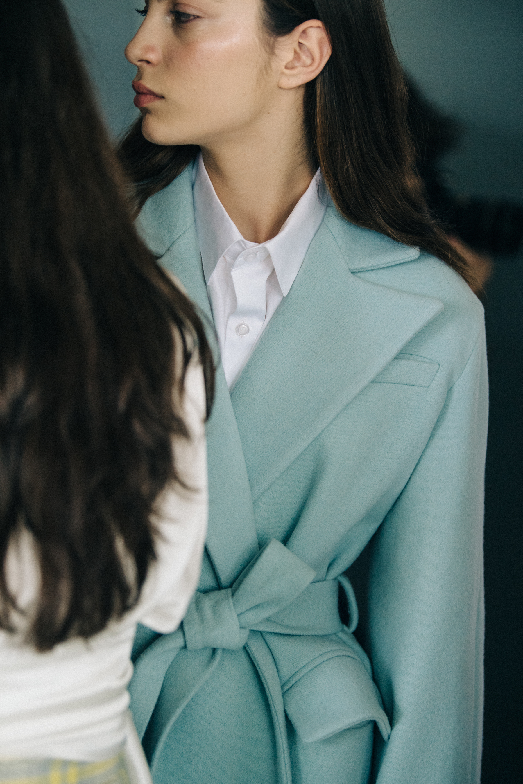 Model wearing blue coat backstage
