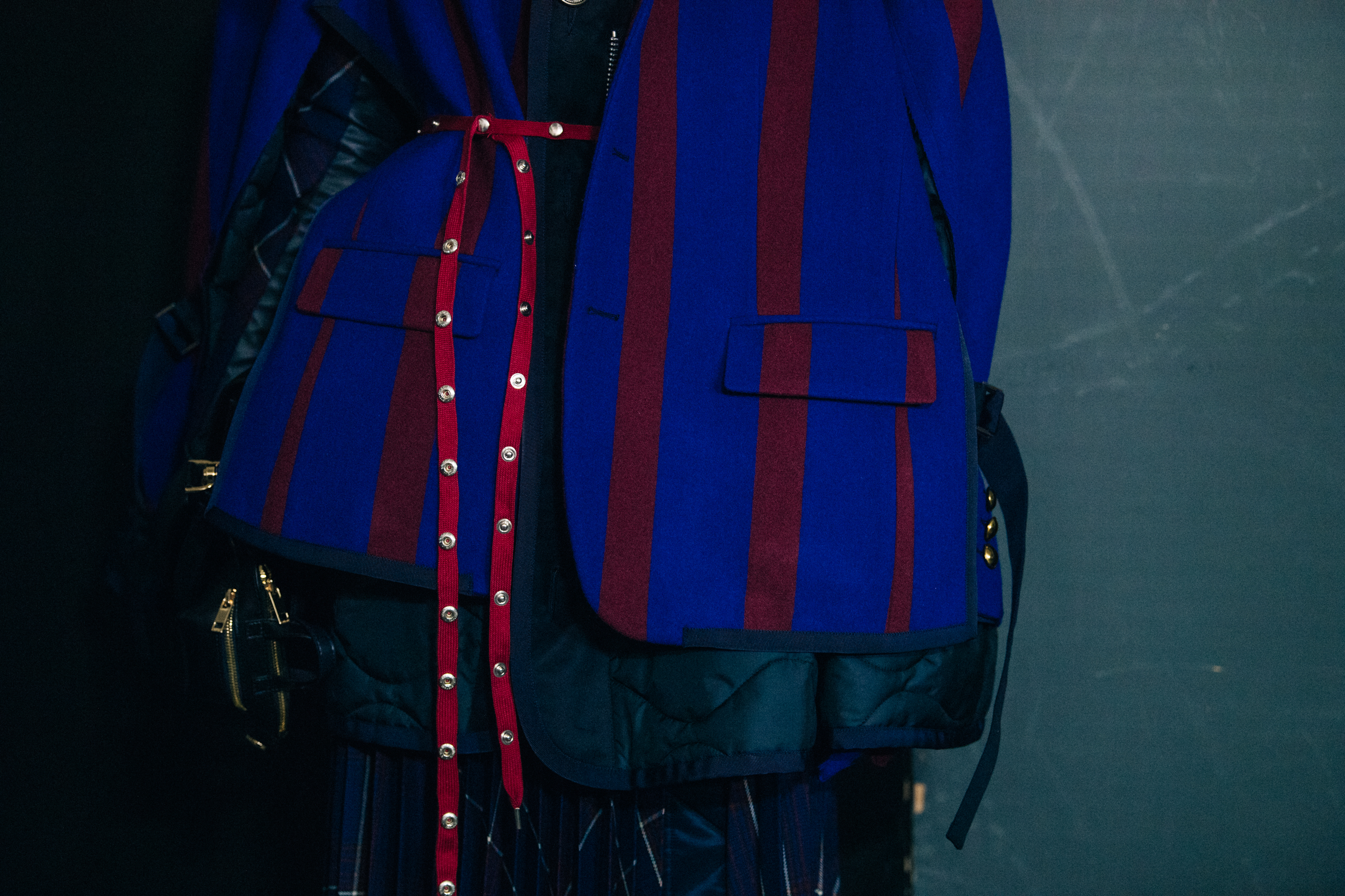 Model wearing blue and red Sacai outfit