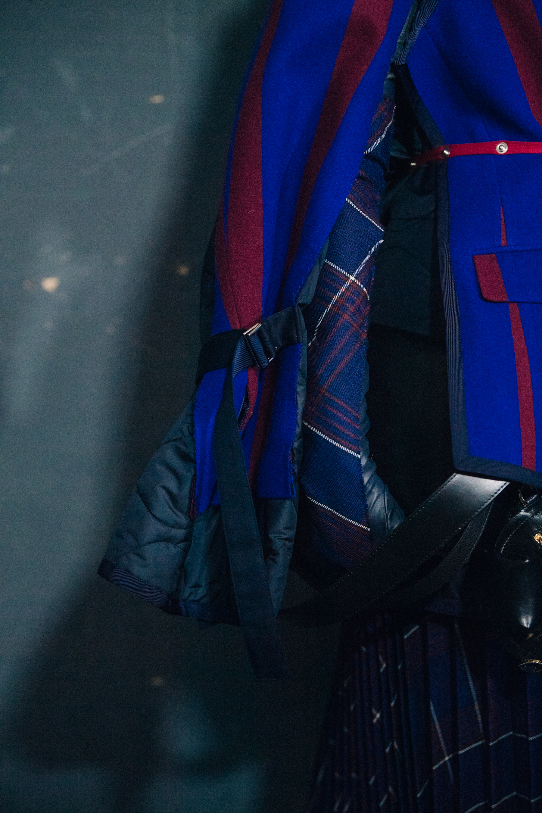 Model wearing blue and red Sacai outfit