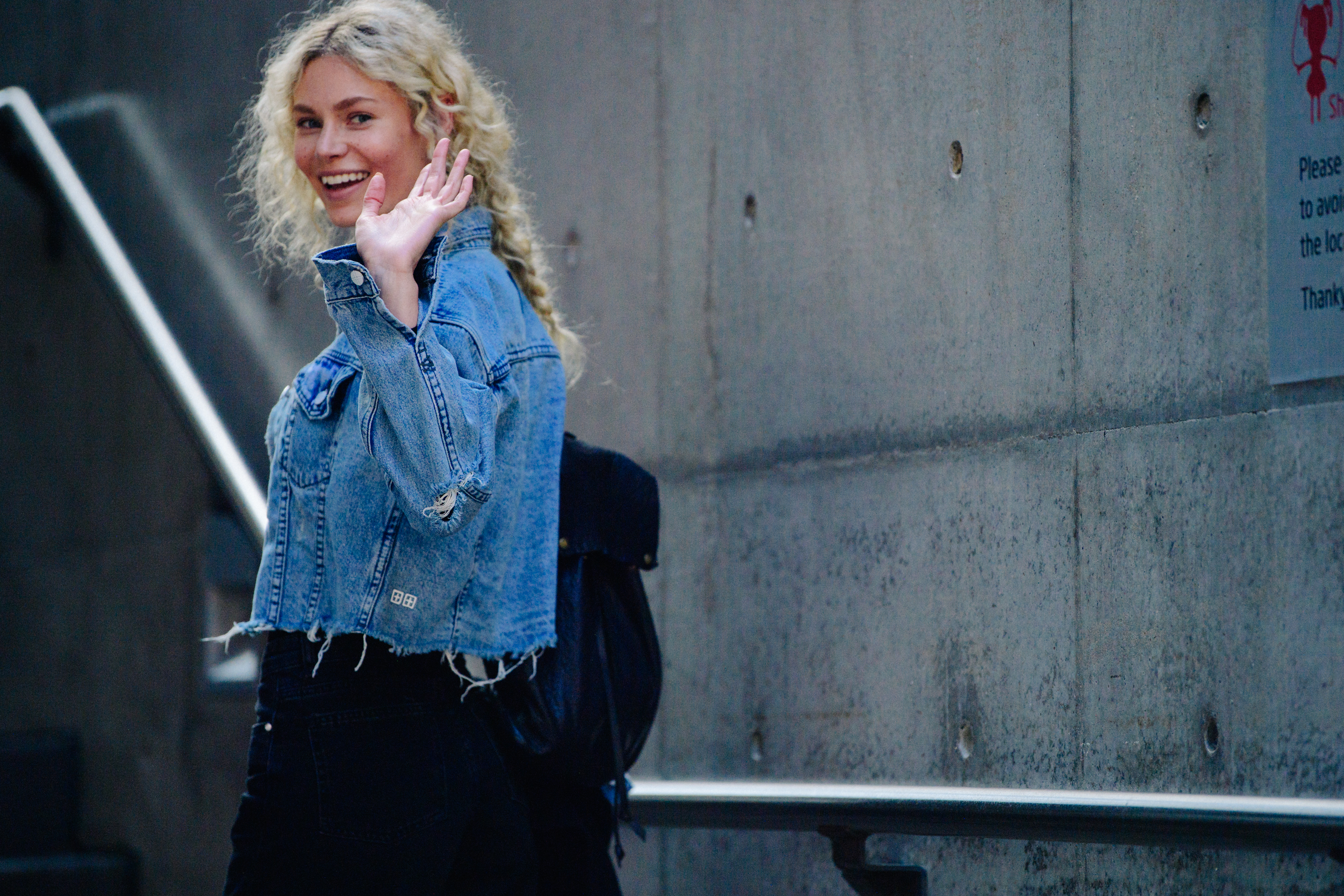 Model waving in denim jacket