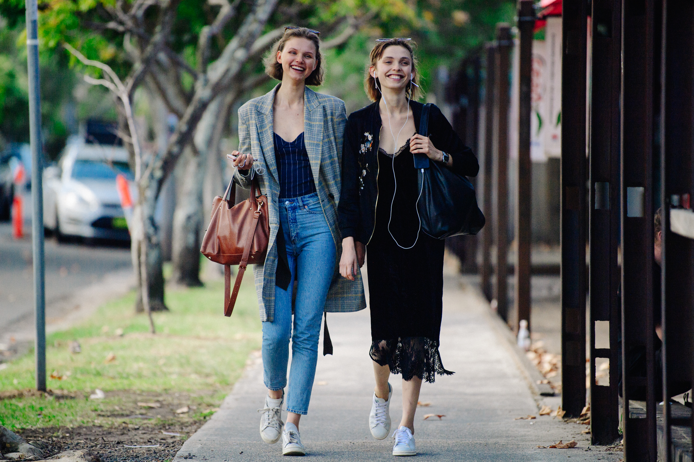 Two women wearing white sneakers