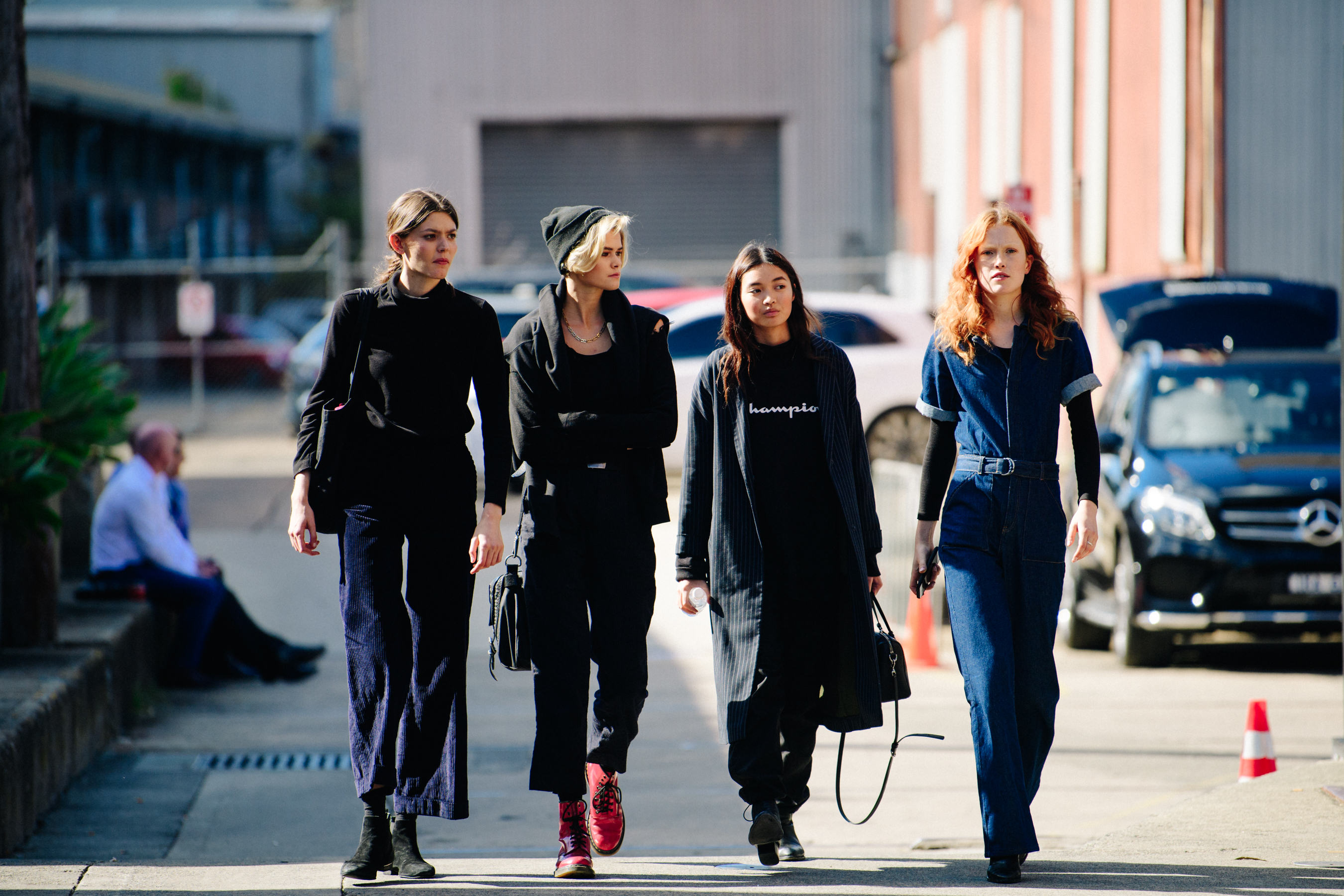 Four women wearing dark outfits