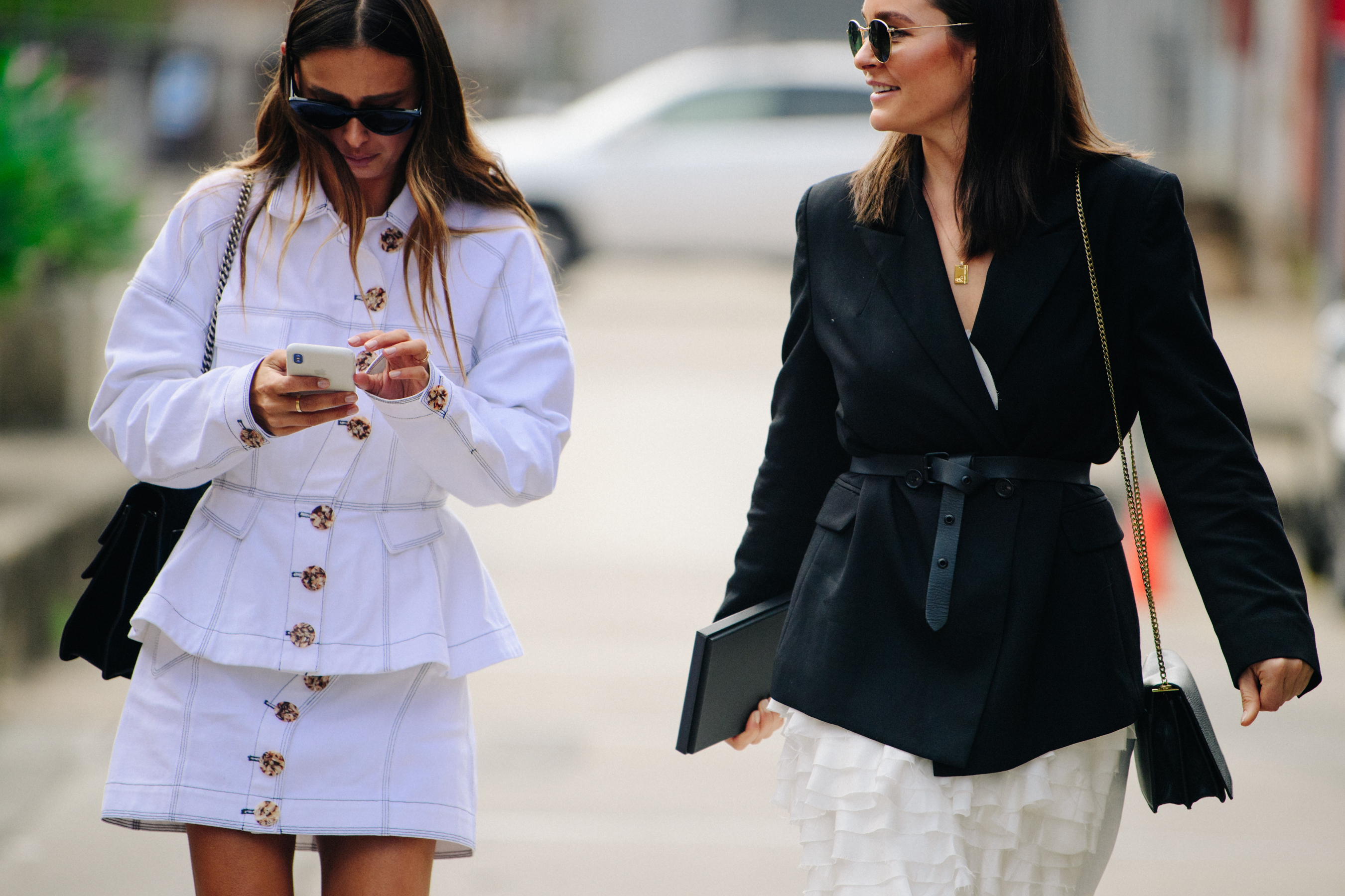 Two women wearing white and black jackets