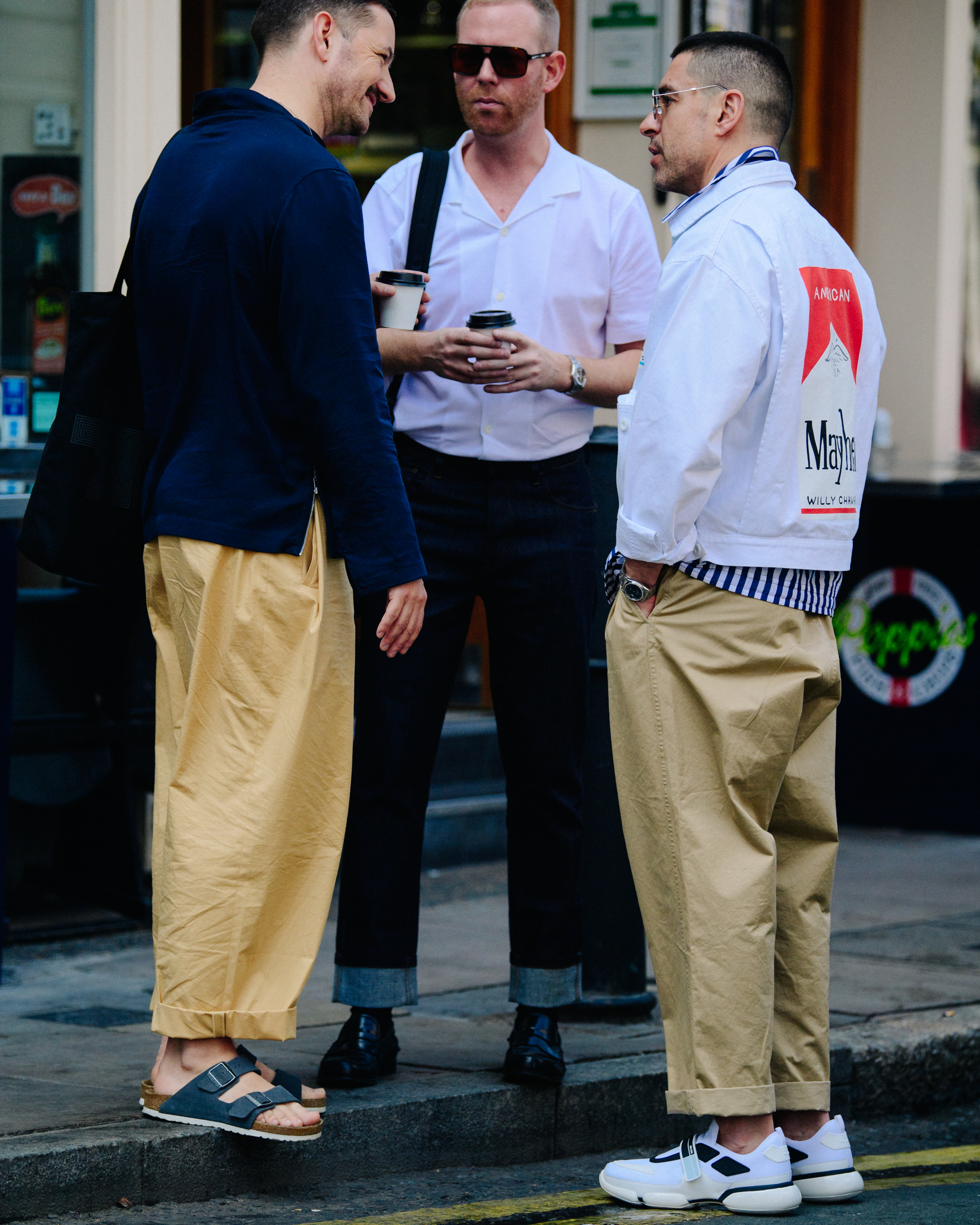 Three men wearing white and tan