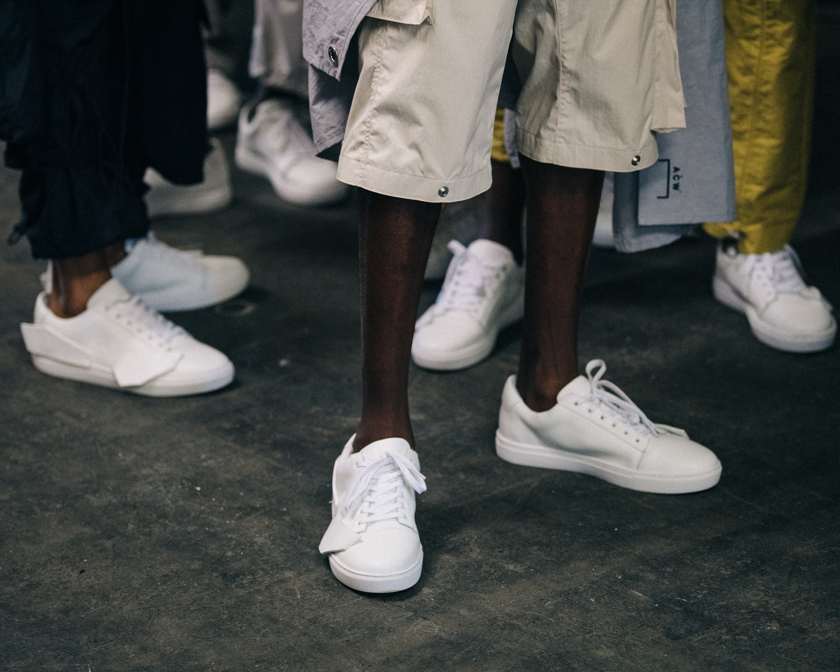 Models wearing white sneakers backstage