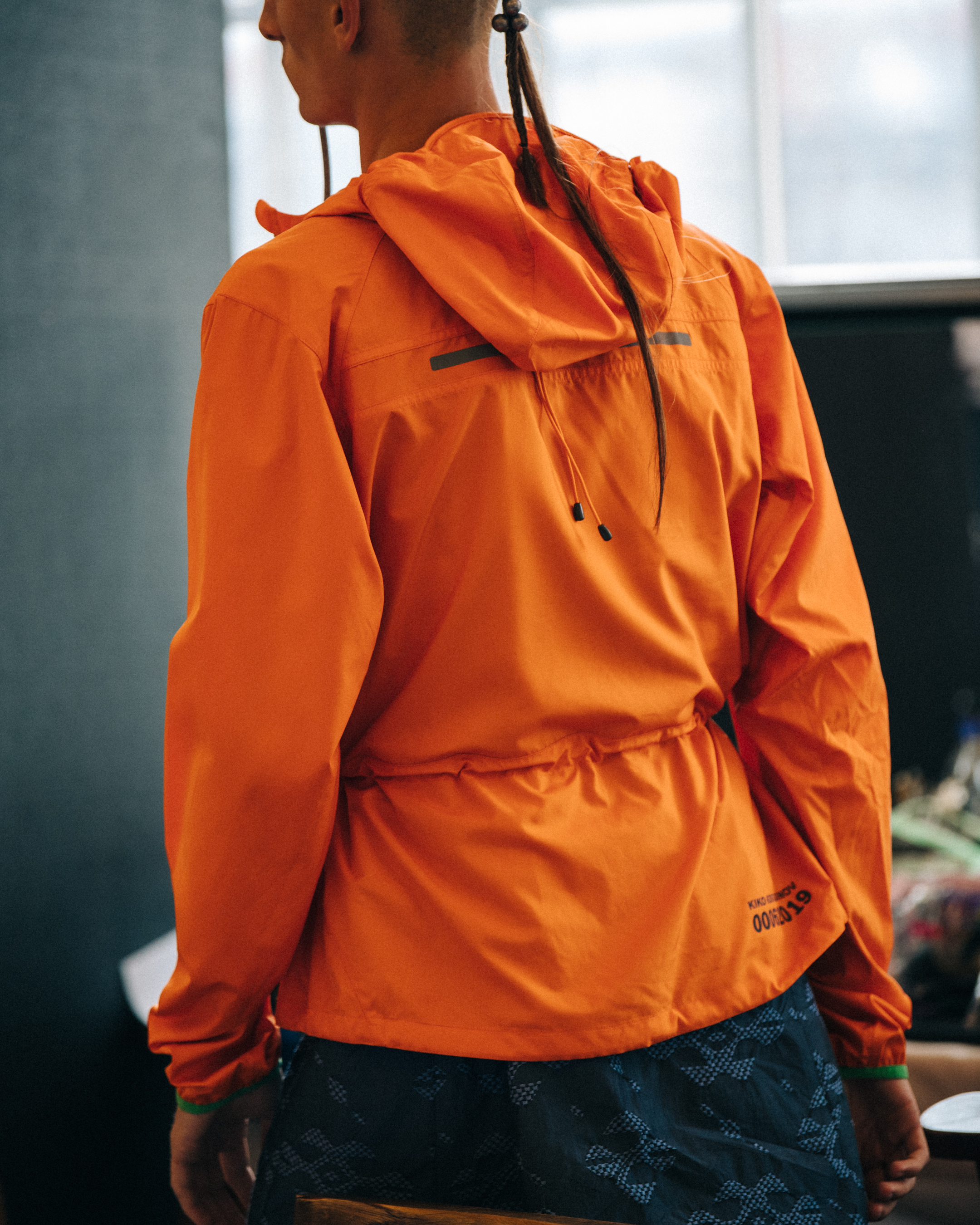 Model wearing orange backstage at Kiko Kostadinov