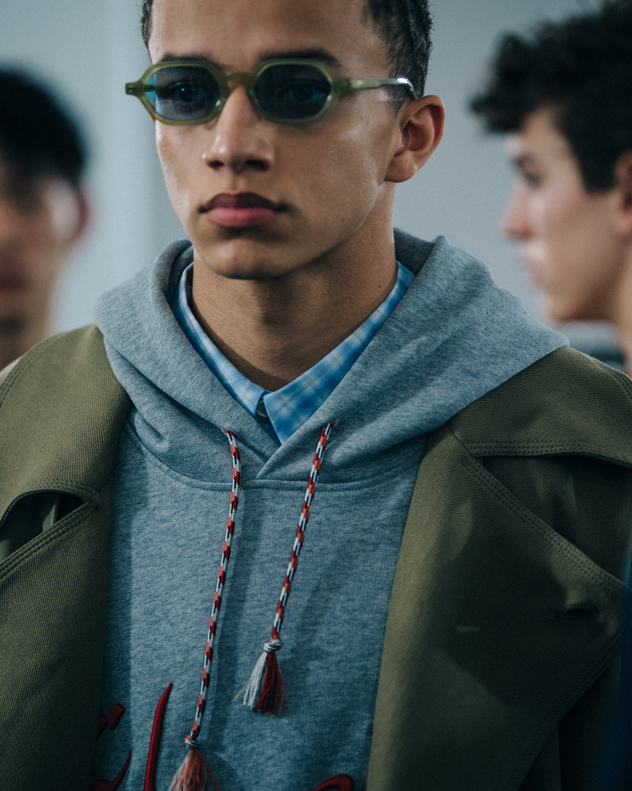 Model wearing grey hoodie at Qasimi