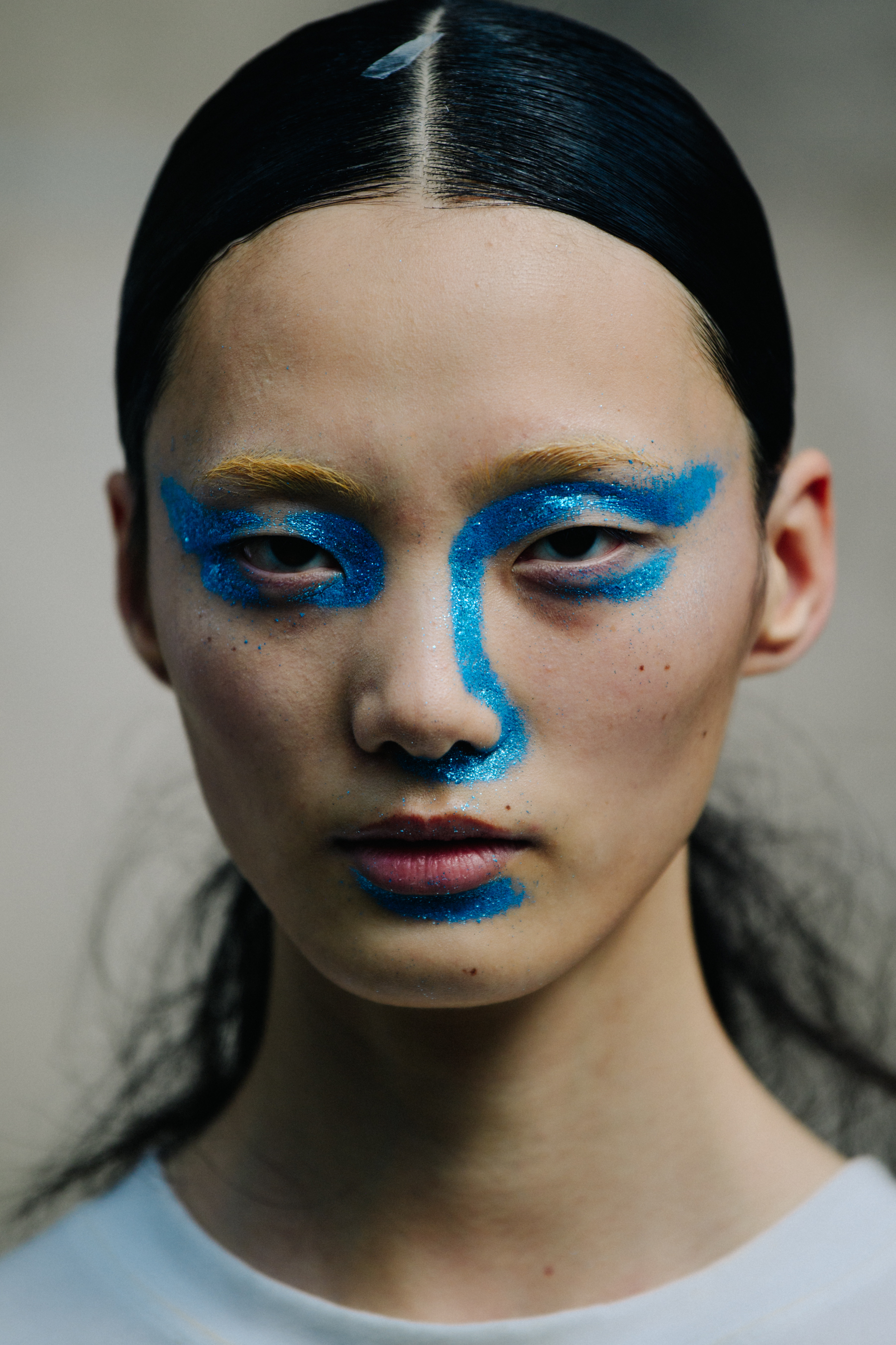 Portrait of model wearing blue face paint