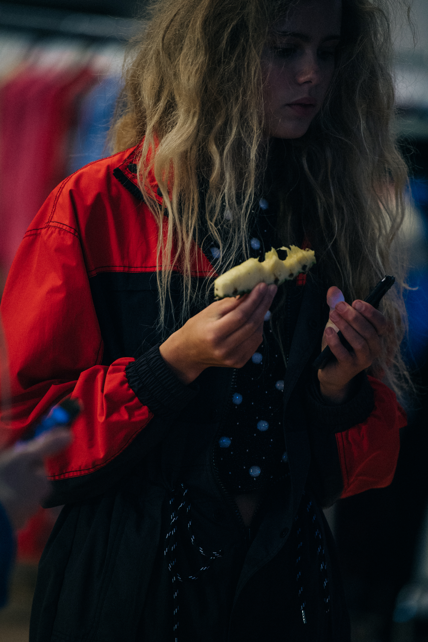 Model wearing red and black jacket backstage