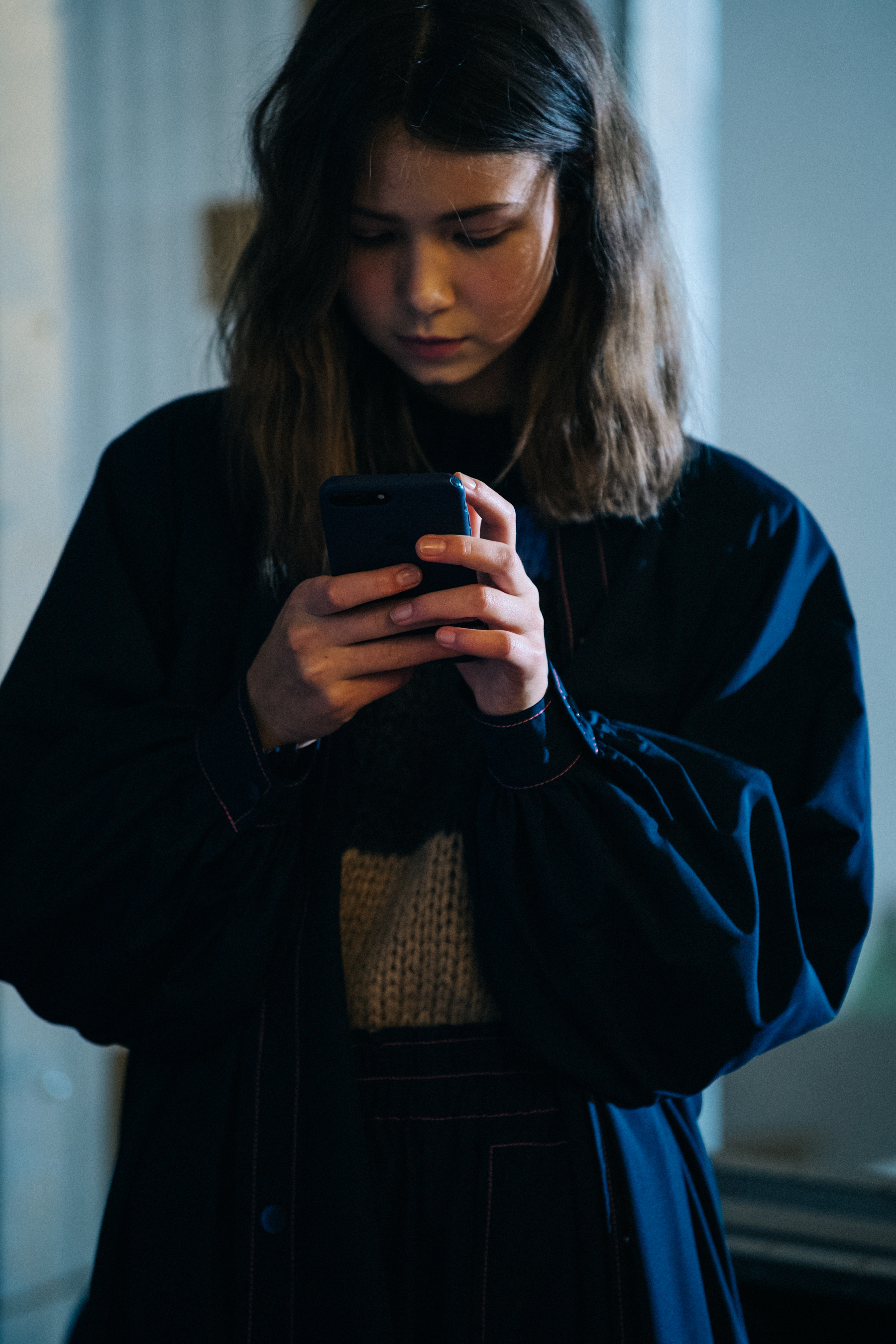 Model using phone backstage at Ganni