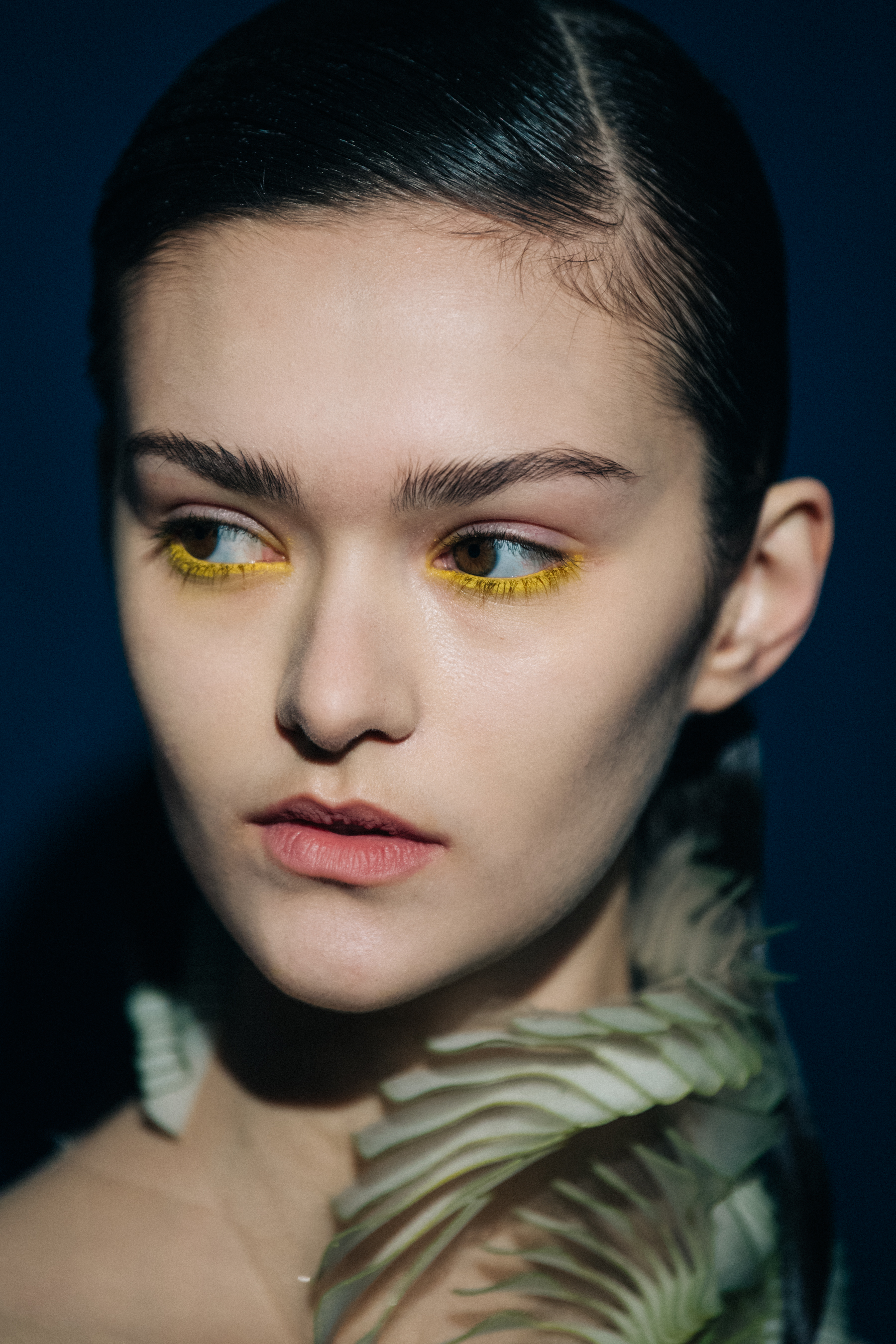 Portrait of model wearing yellow eye makeup