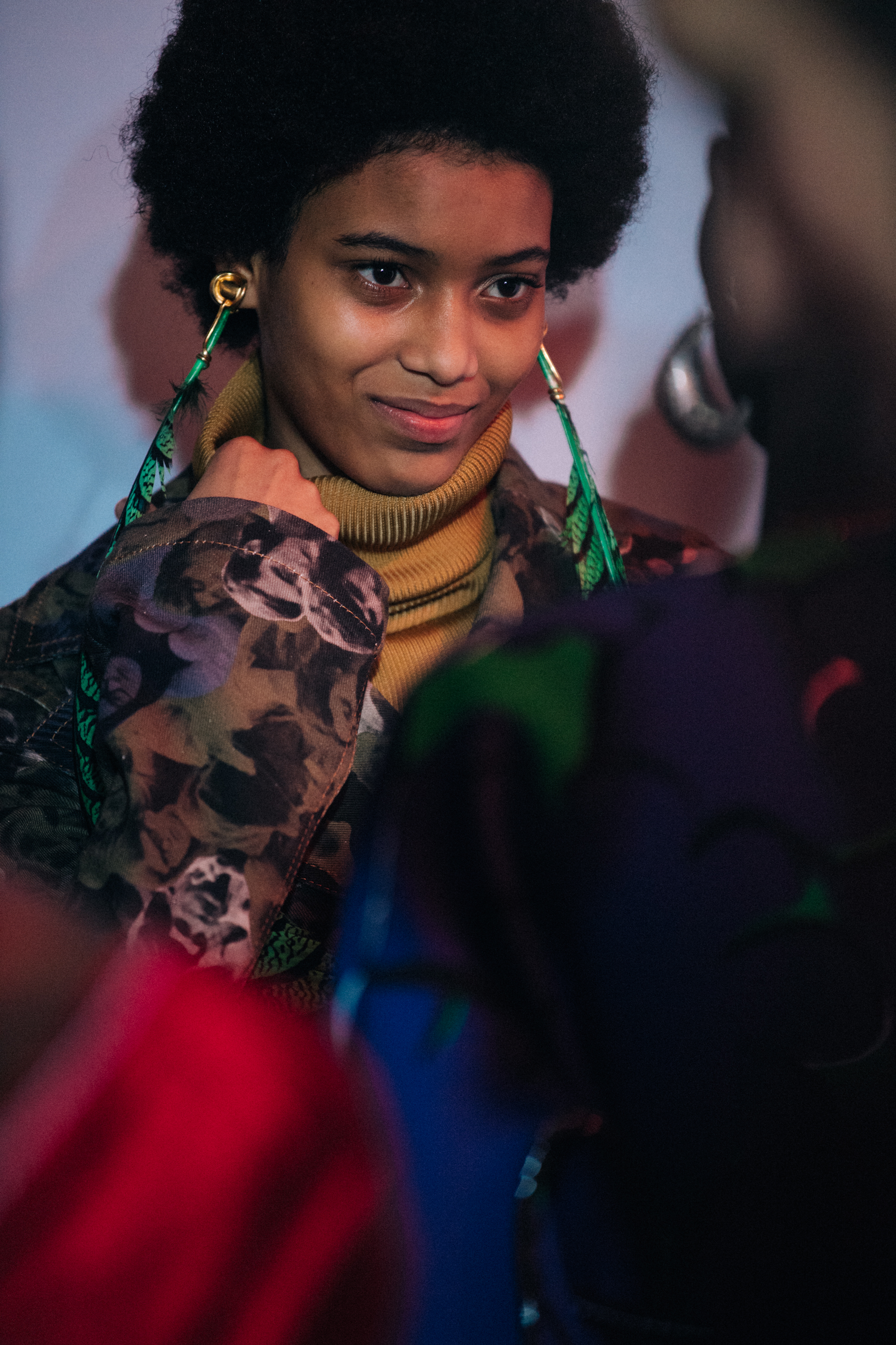 Model wearing green feather earrings