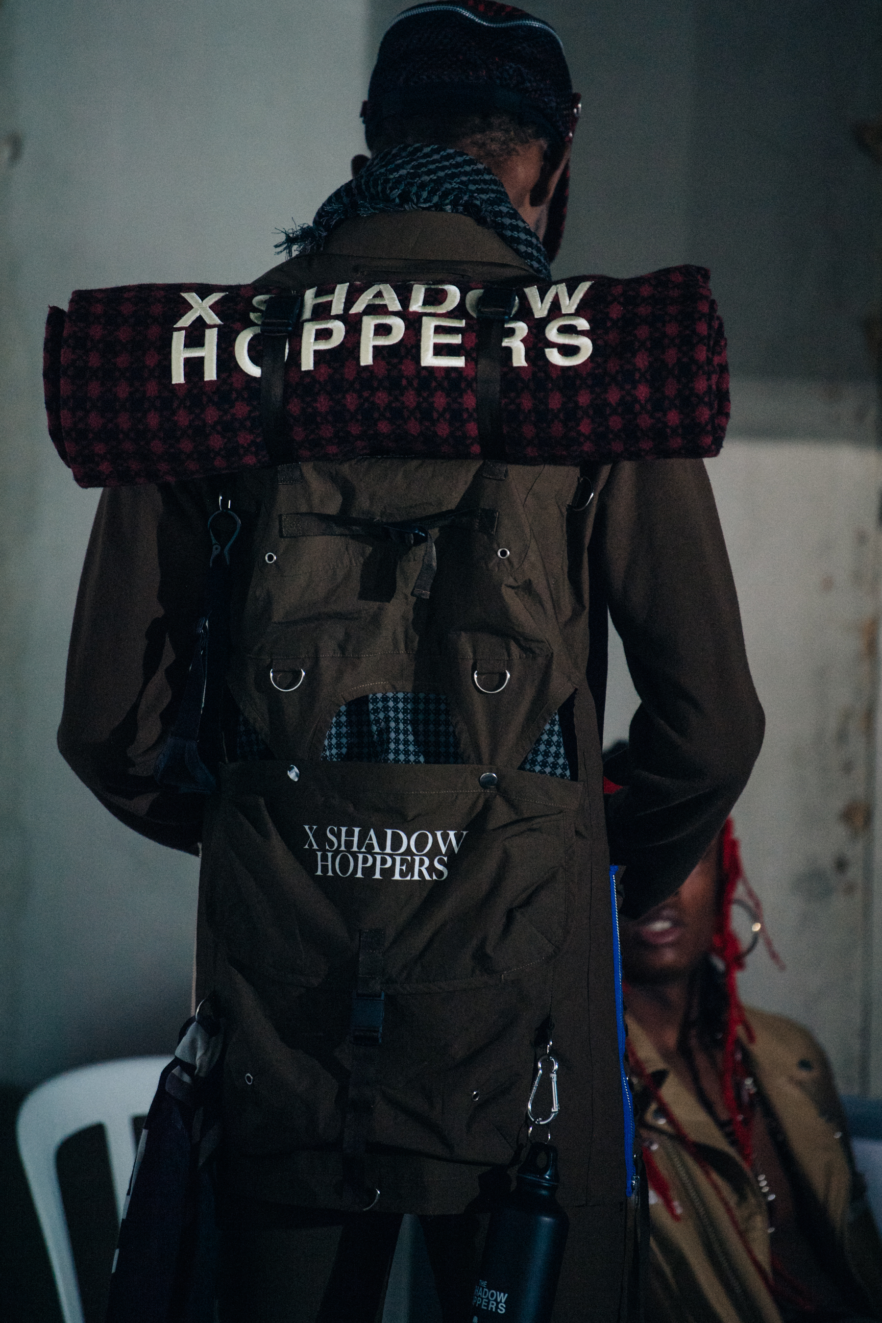 Model wearing backpack backstage at Undercover