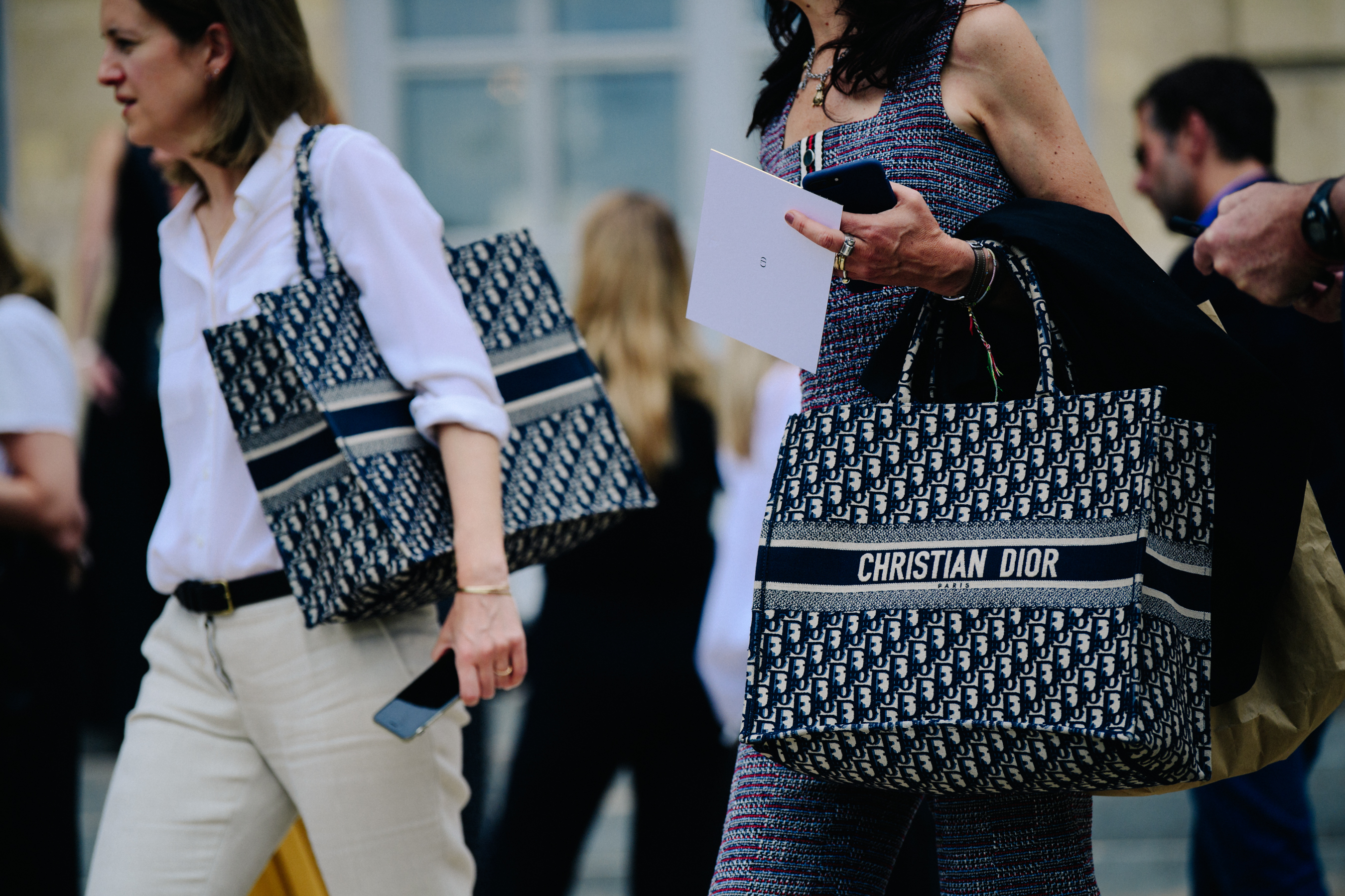 Two women carrying Christian Christian Dior bags