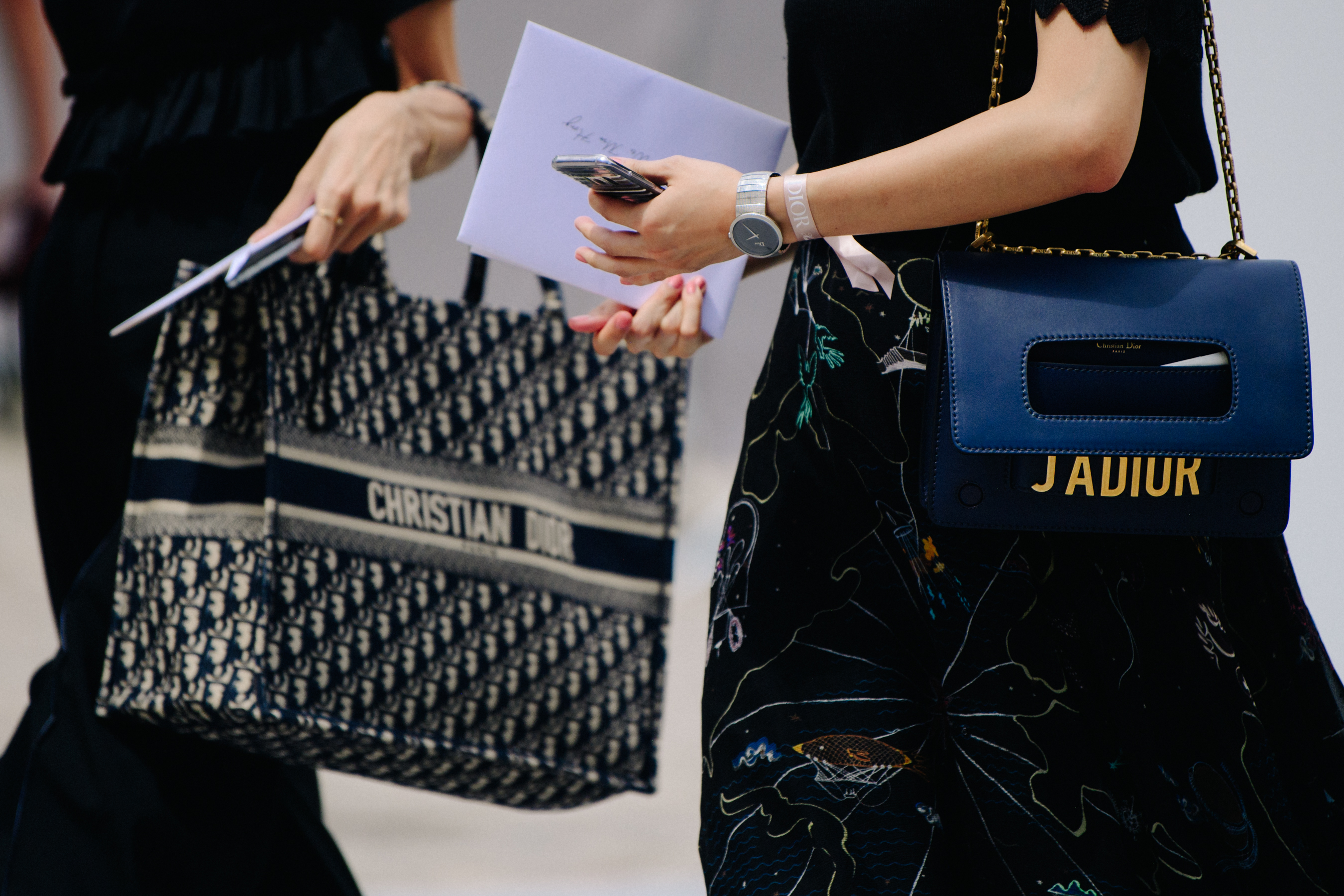 Two women carrying Christian Dior bags