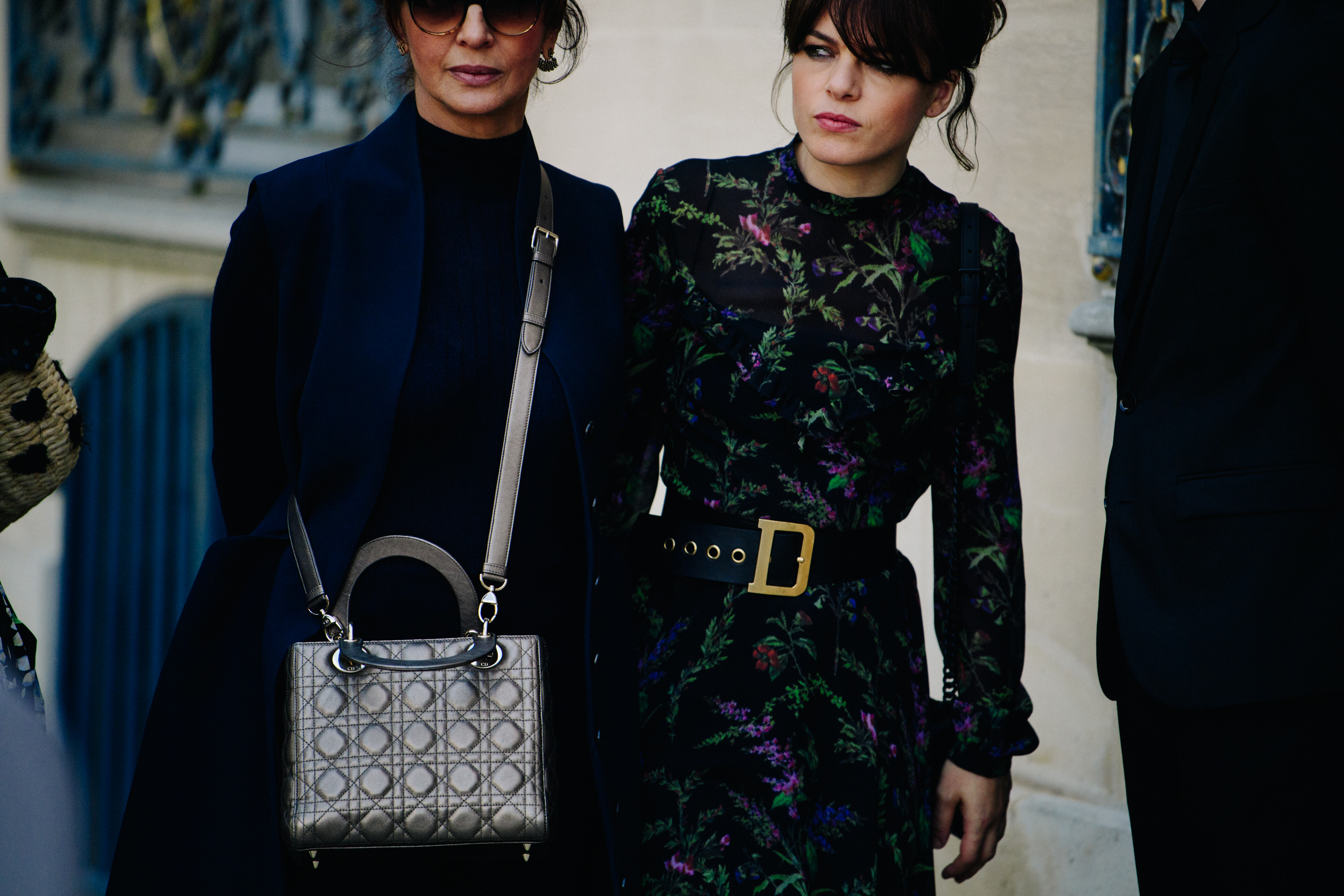 Two women wearing dark dresses