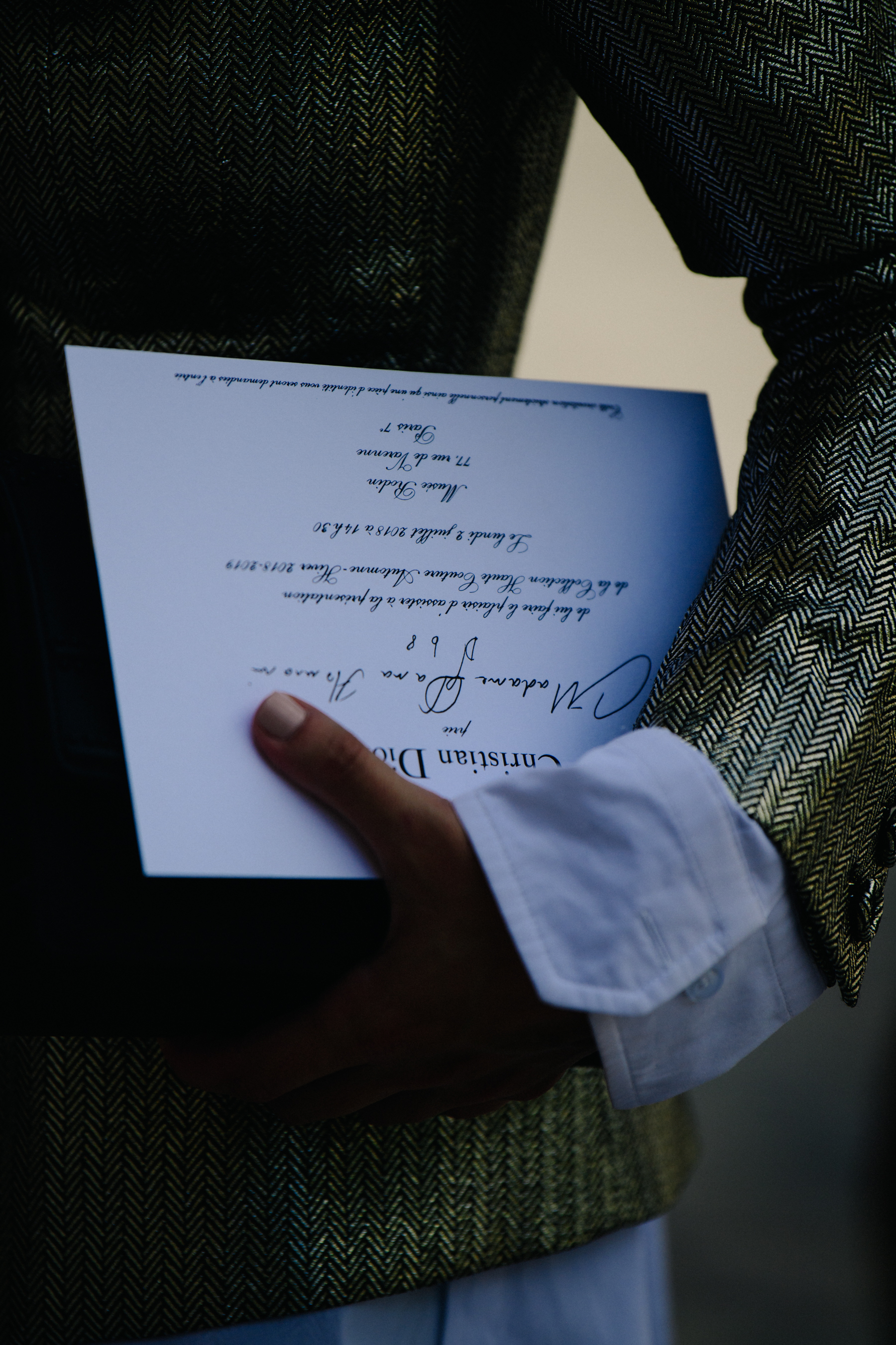 Woman carrying Christian Dior show invite