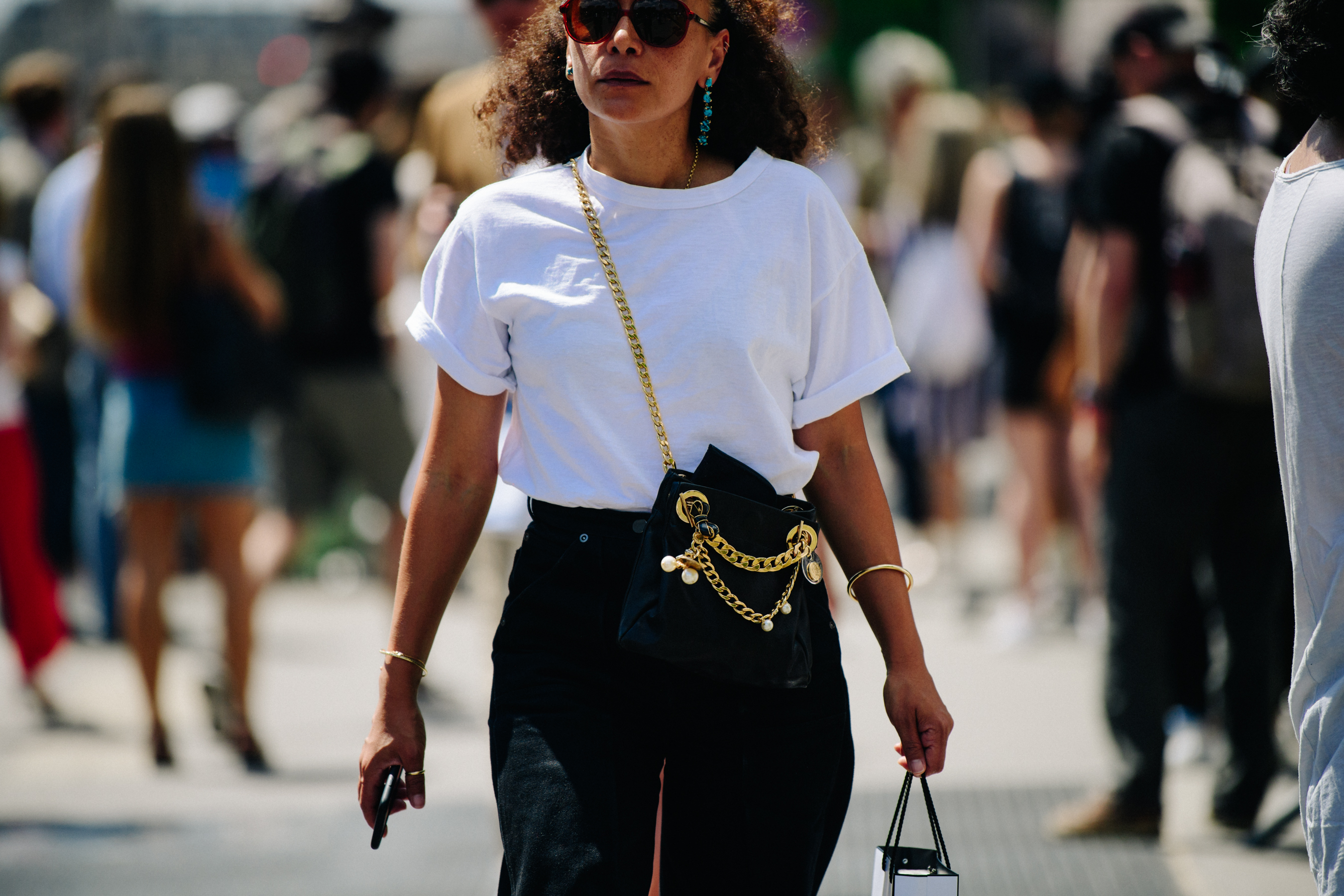Woman wearing black bag with gold chain
