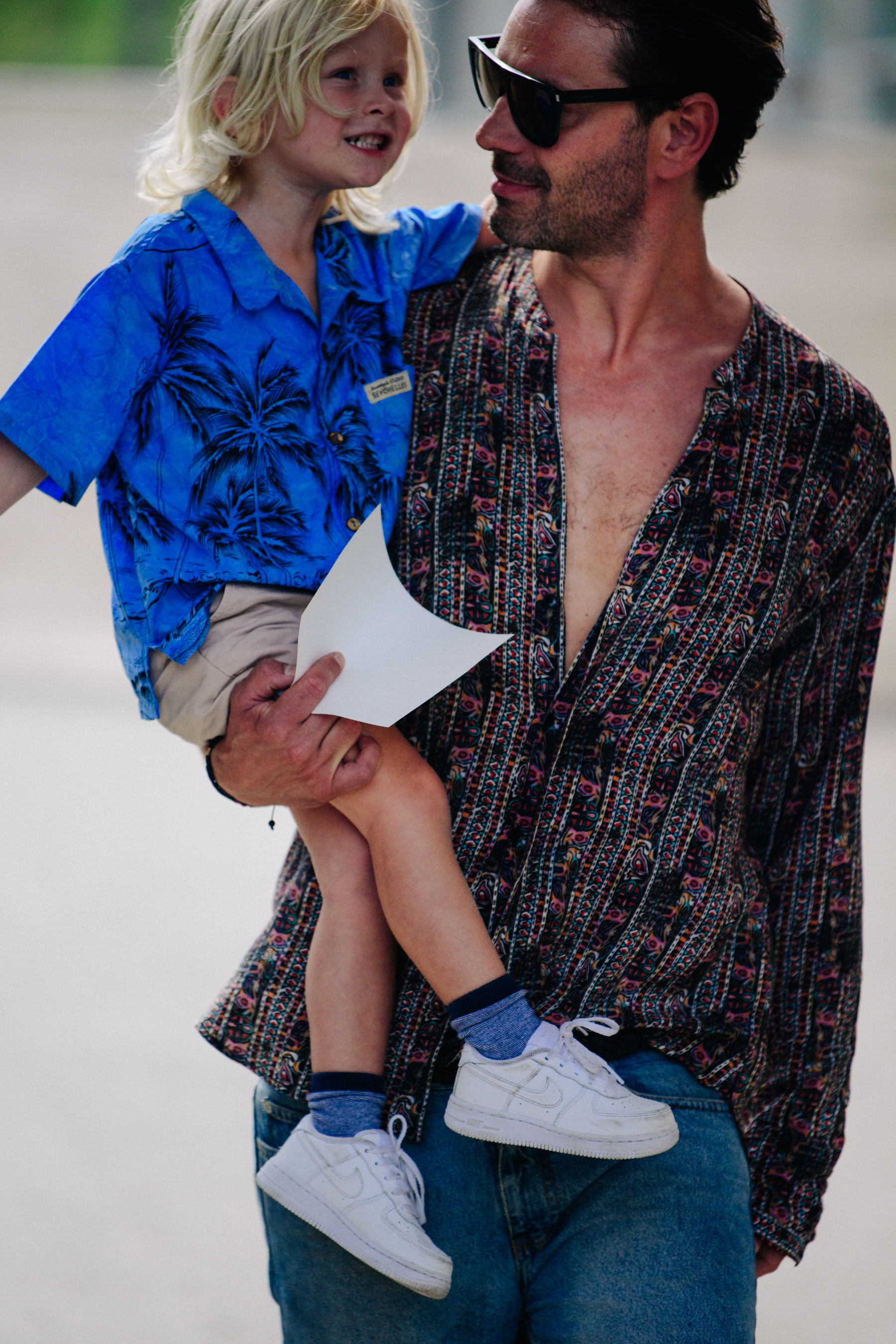 Father carrying child at fashion show