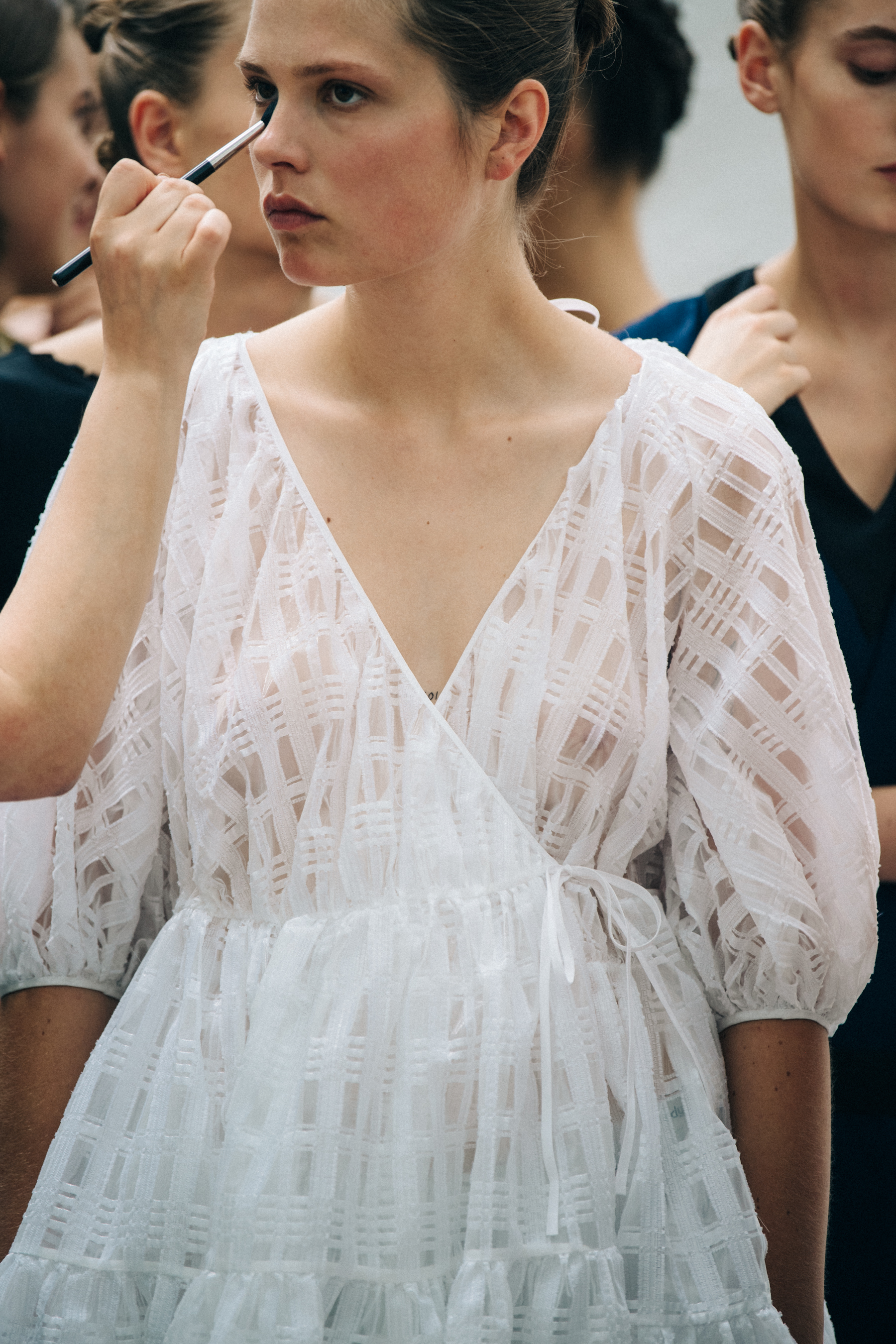 Model having makeup applied at Cecilie Bahnsen
