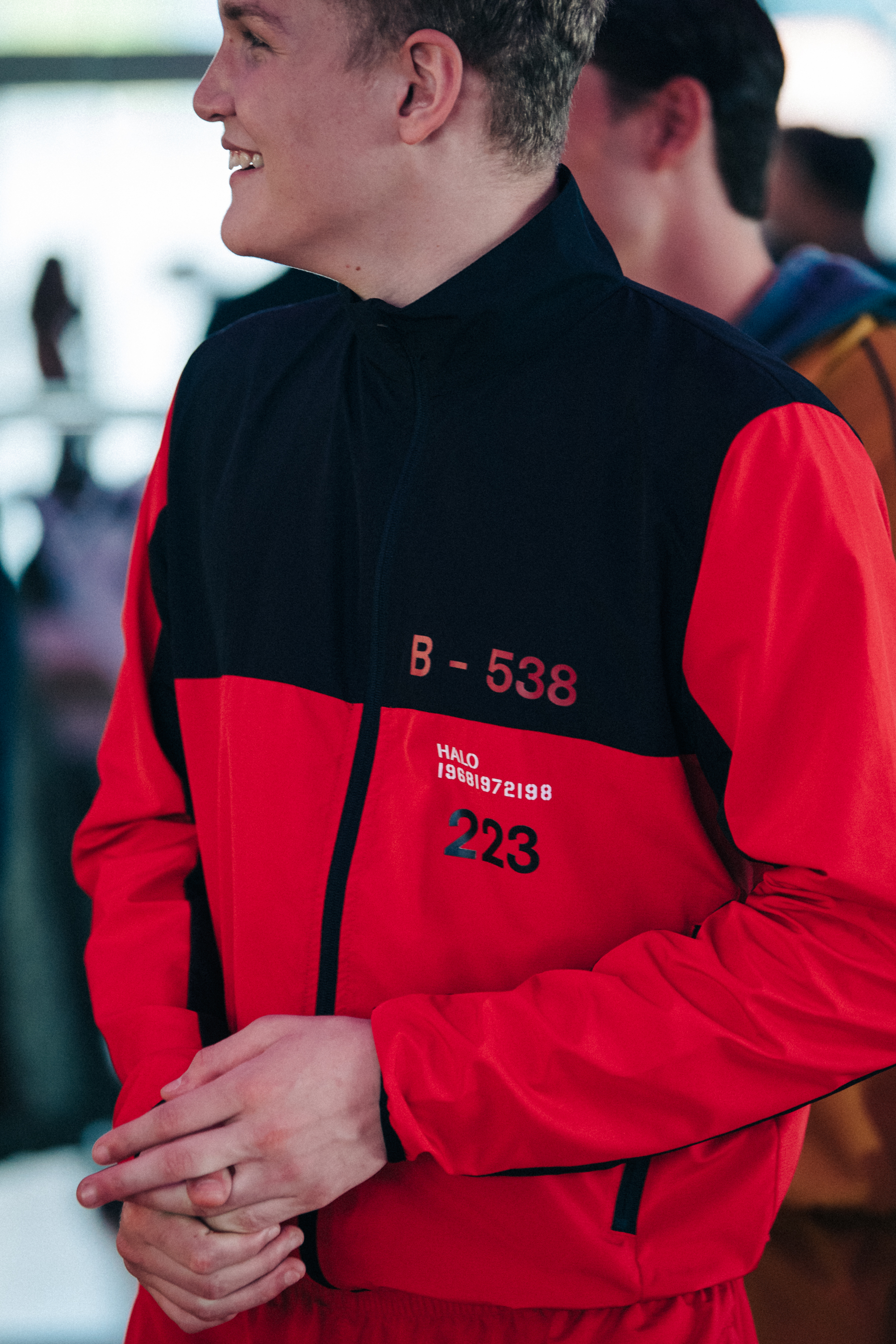 Model wearing black and red tracksuit backstage