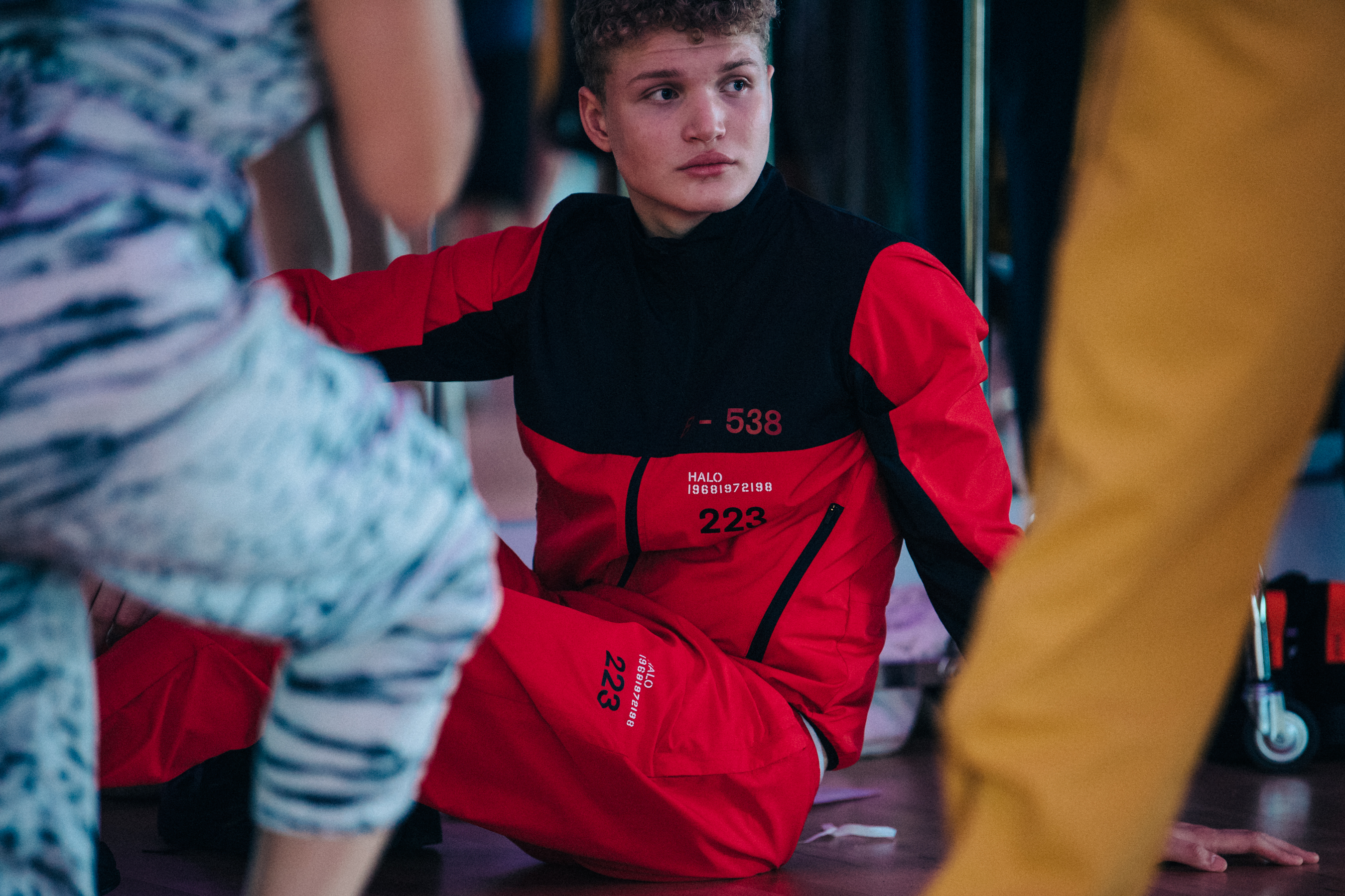 Model wearing black and red tracksuit backstage