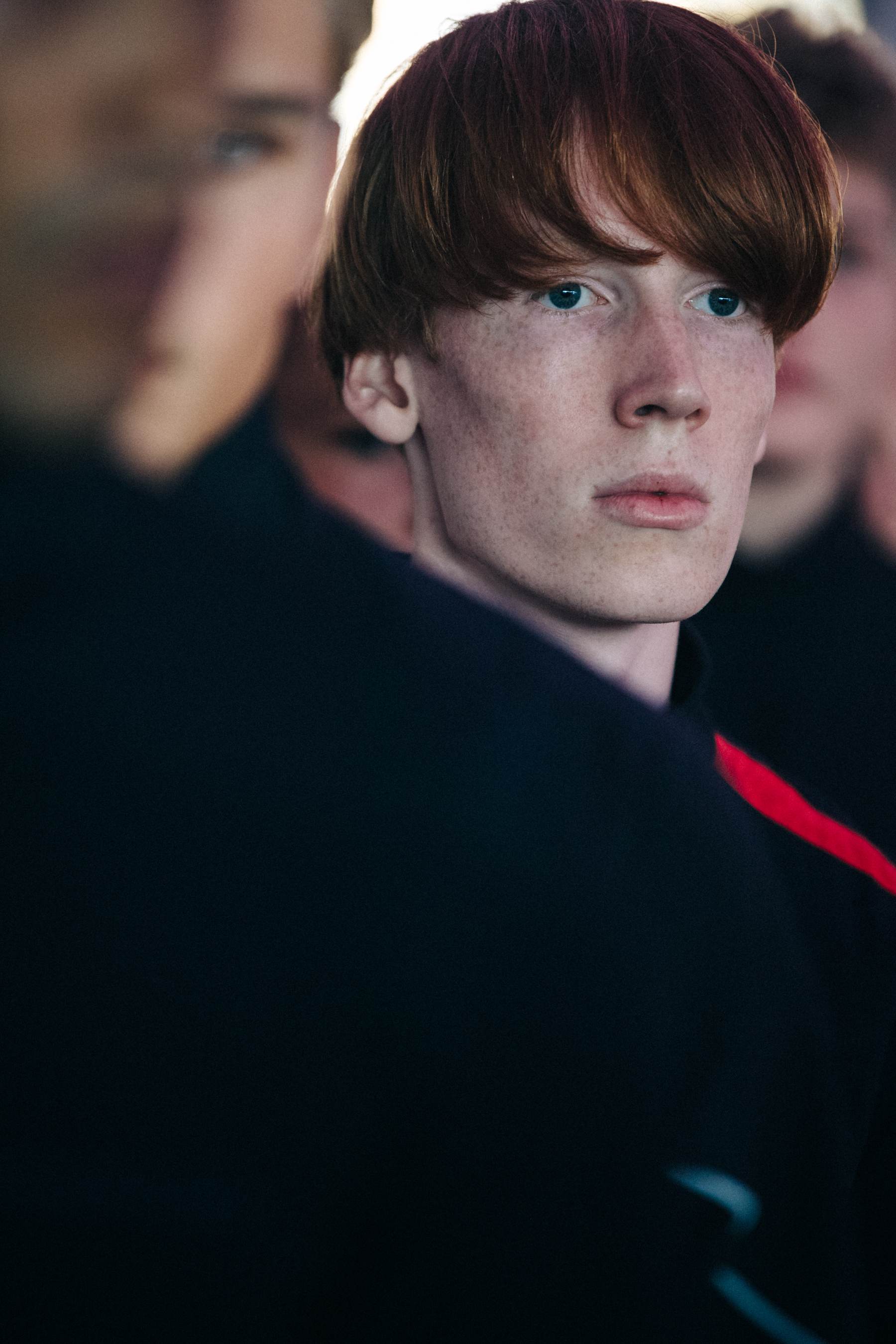 Model wearing black and red tracksuit backstage