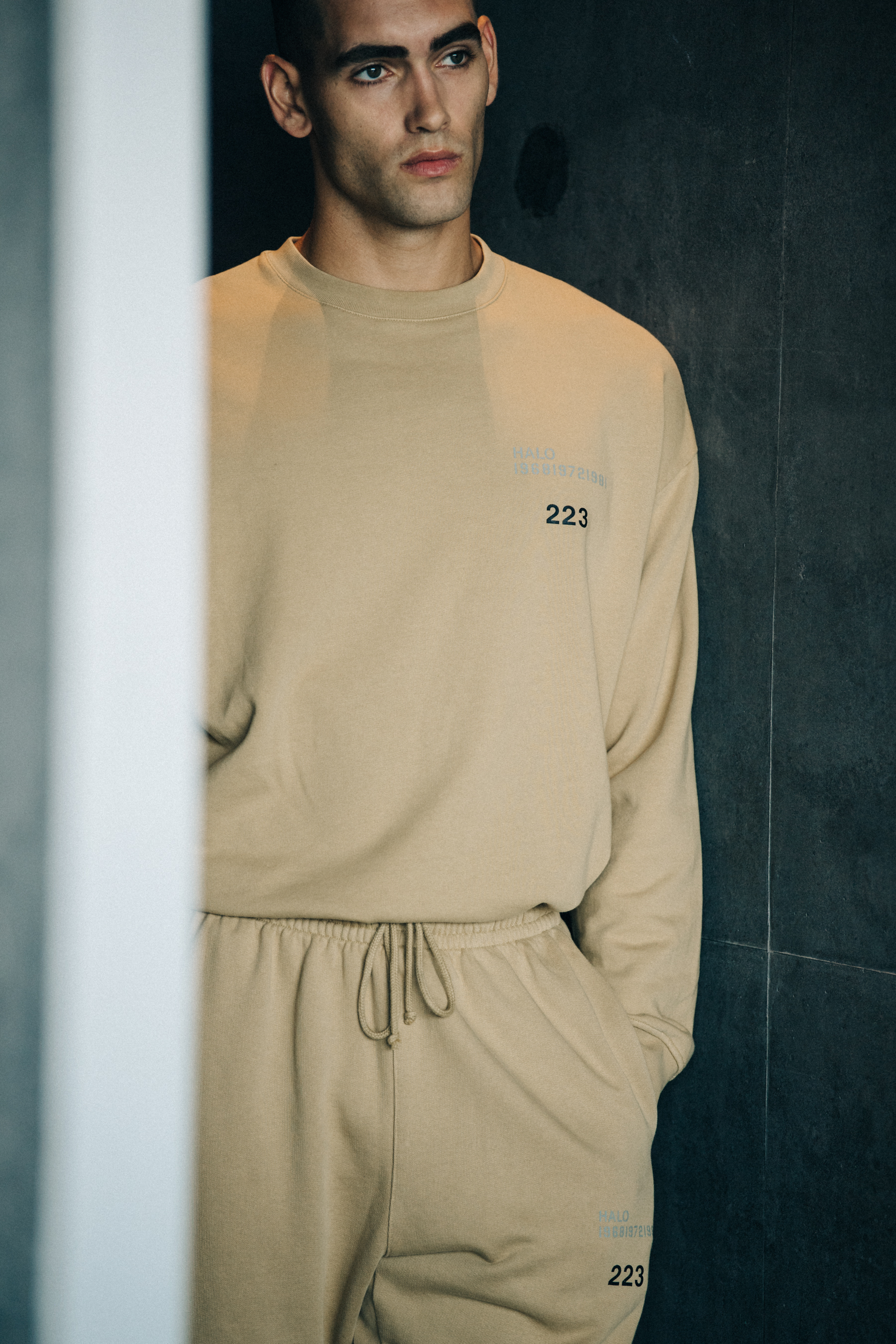 Model wearing light yellow tracksuit