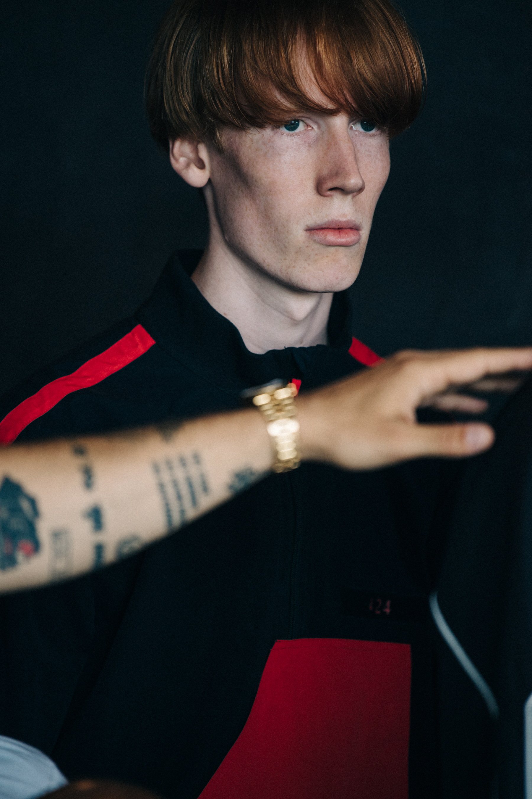 Model wearing black and red tracksuit backstage