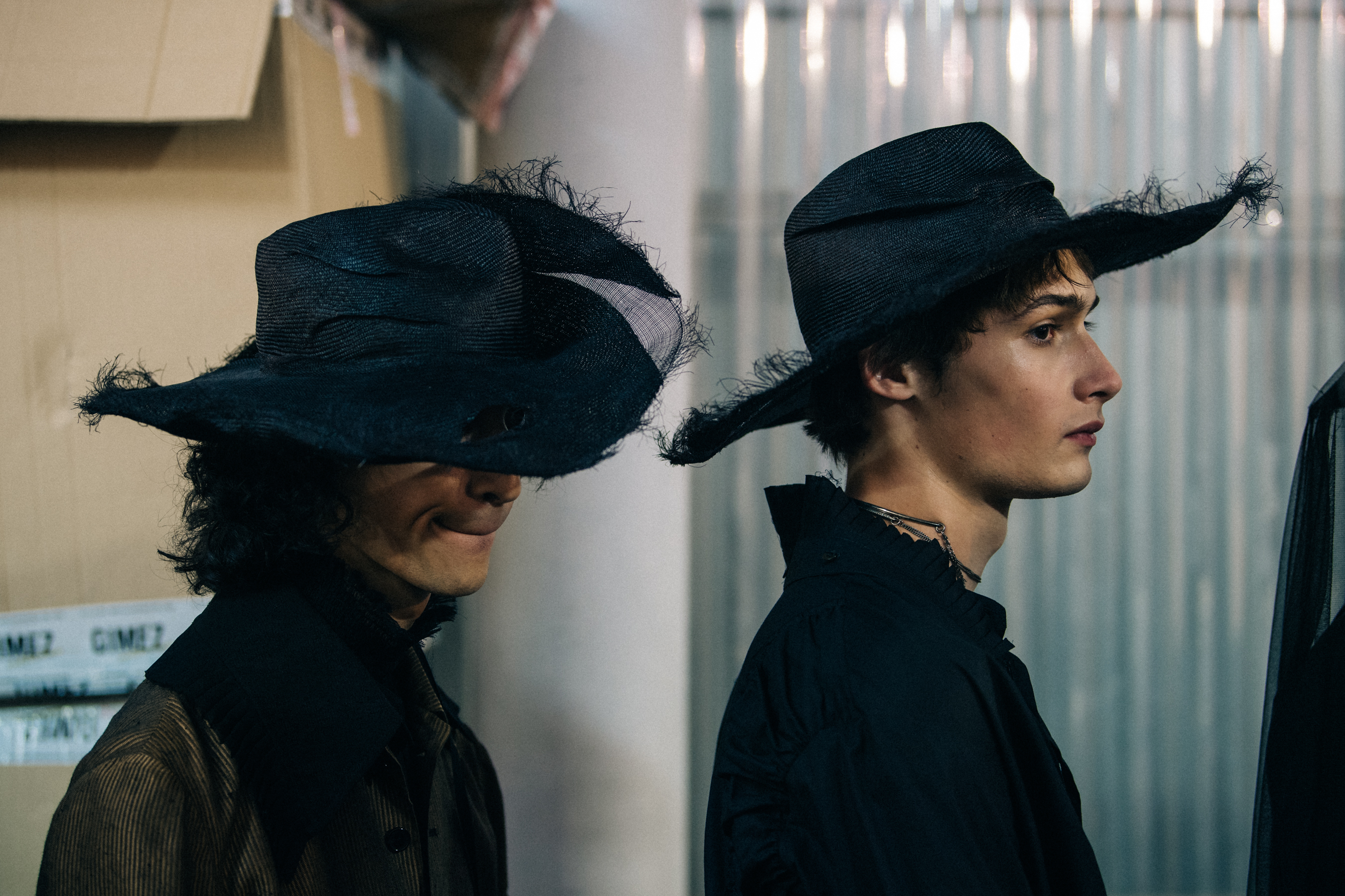 Model wearing black rimmed hat backstage
