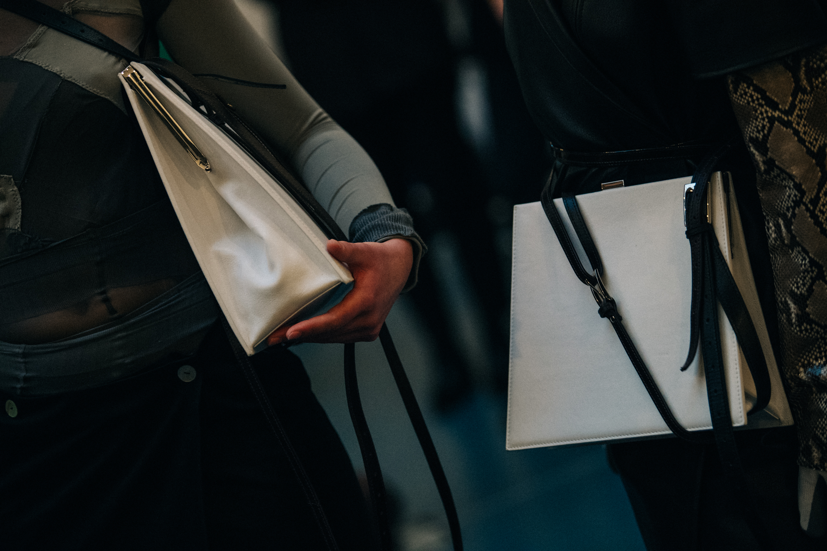 Model holding white leather bag backstage