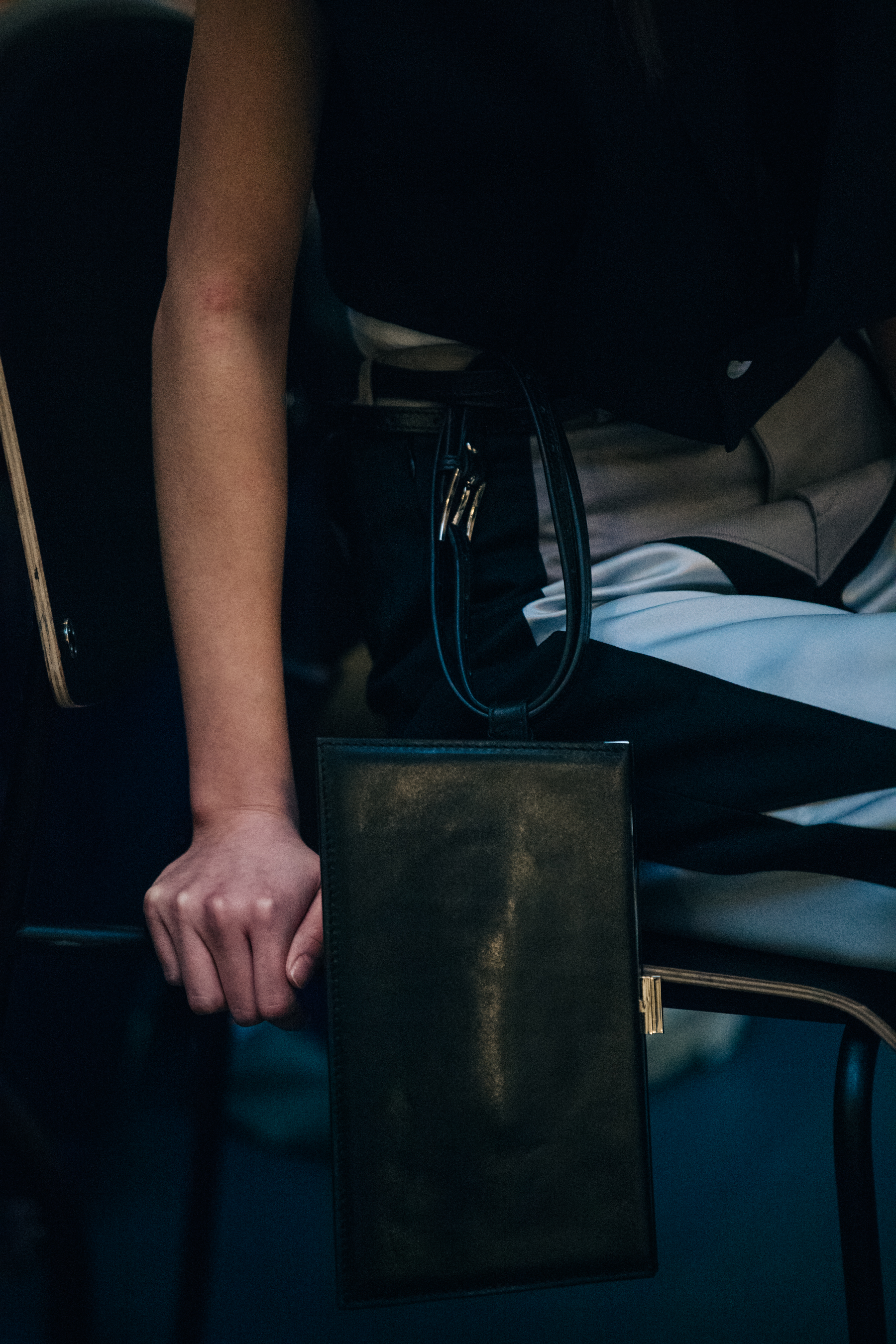 Model wearing grey and black trousers backstage