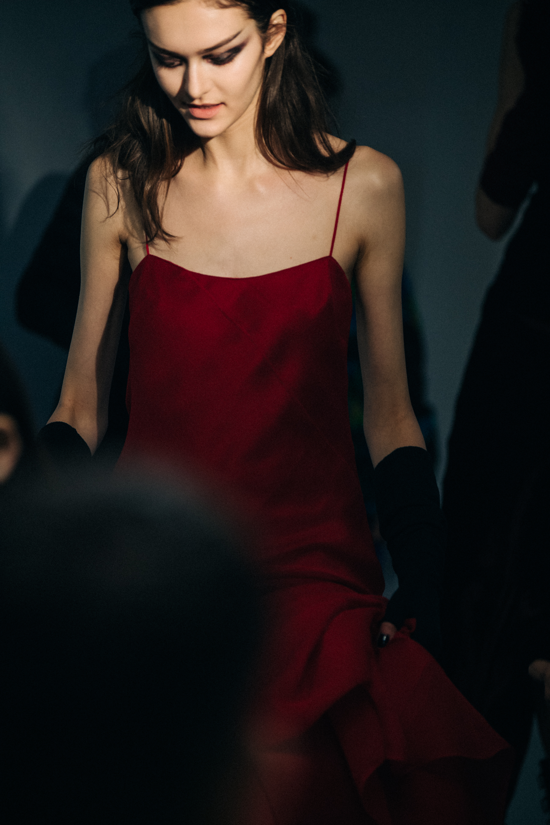 Model wearing red dress backstage