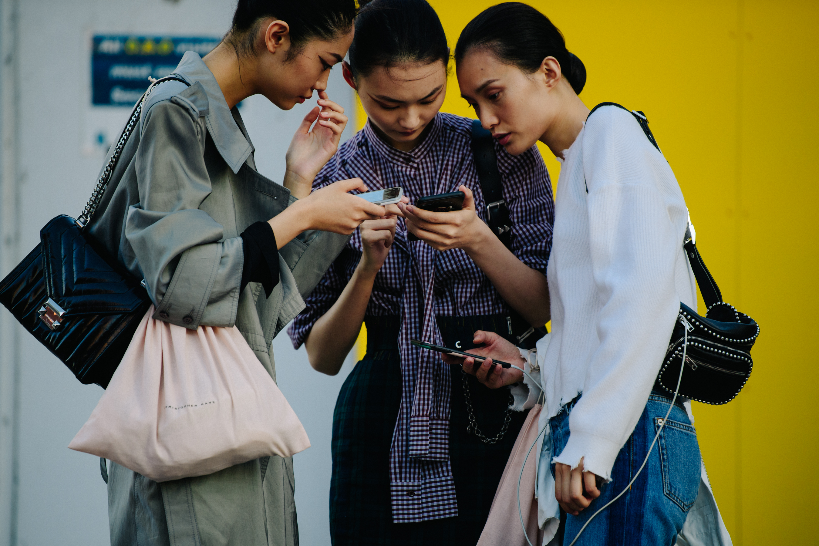 Three models looking at iPhones