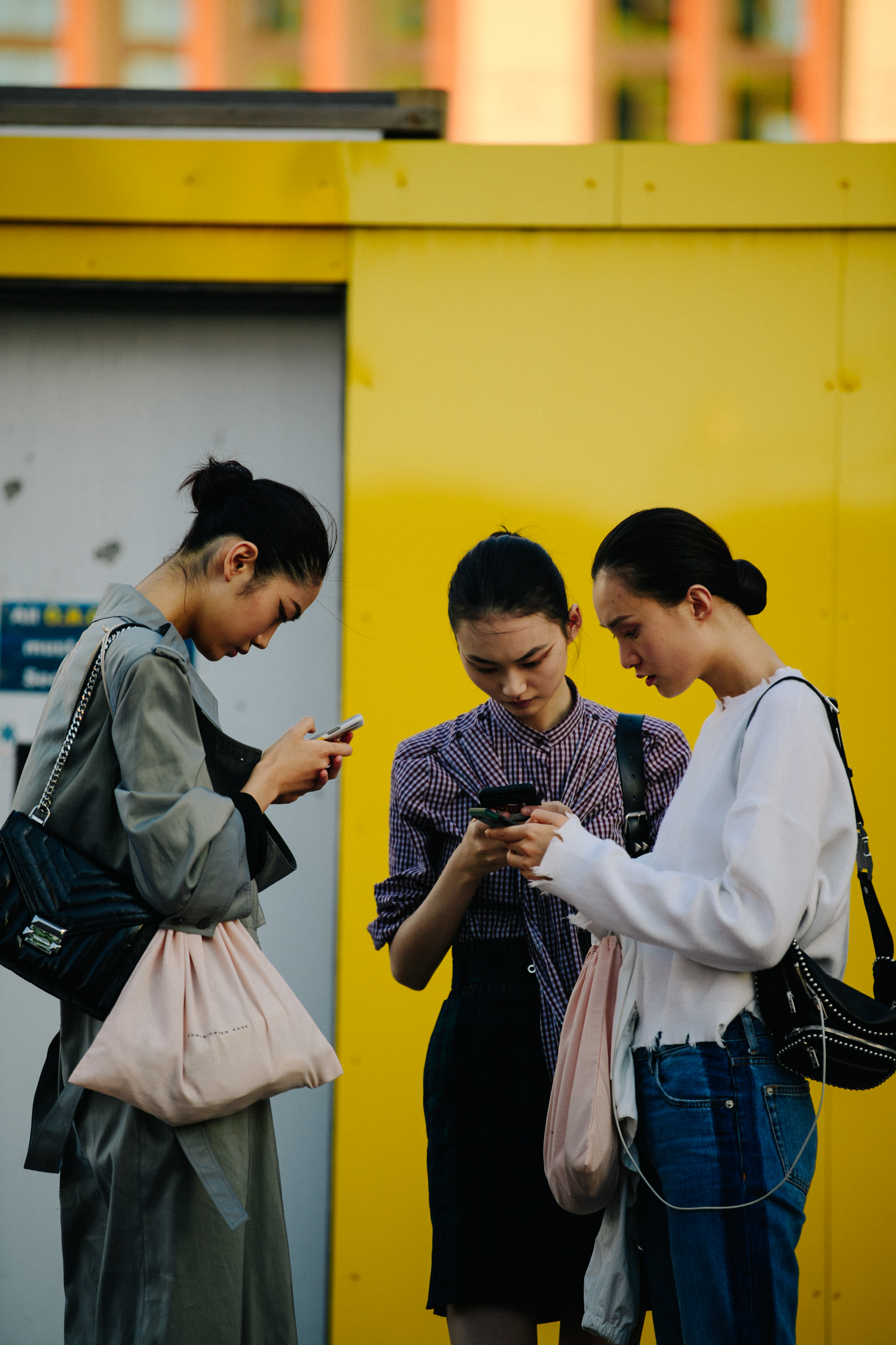 Three models looking at iPhones
