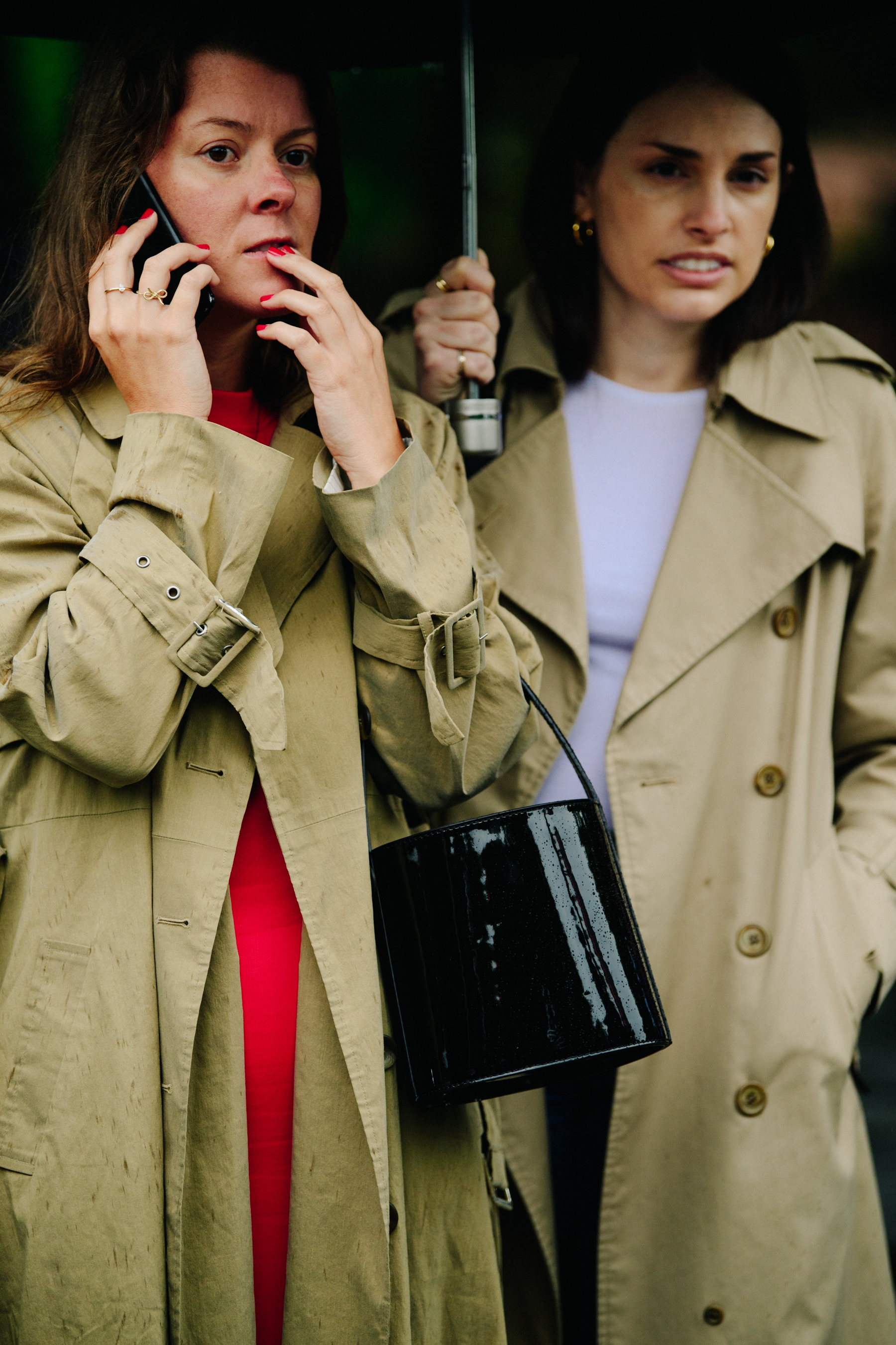 Two women wearing trench coats