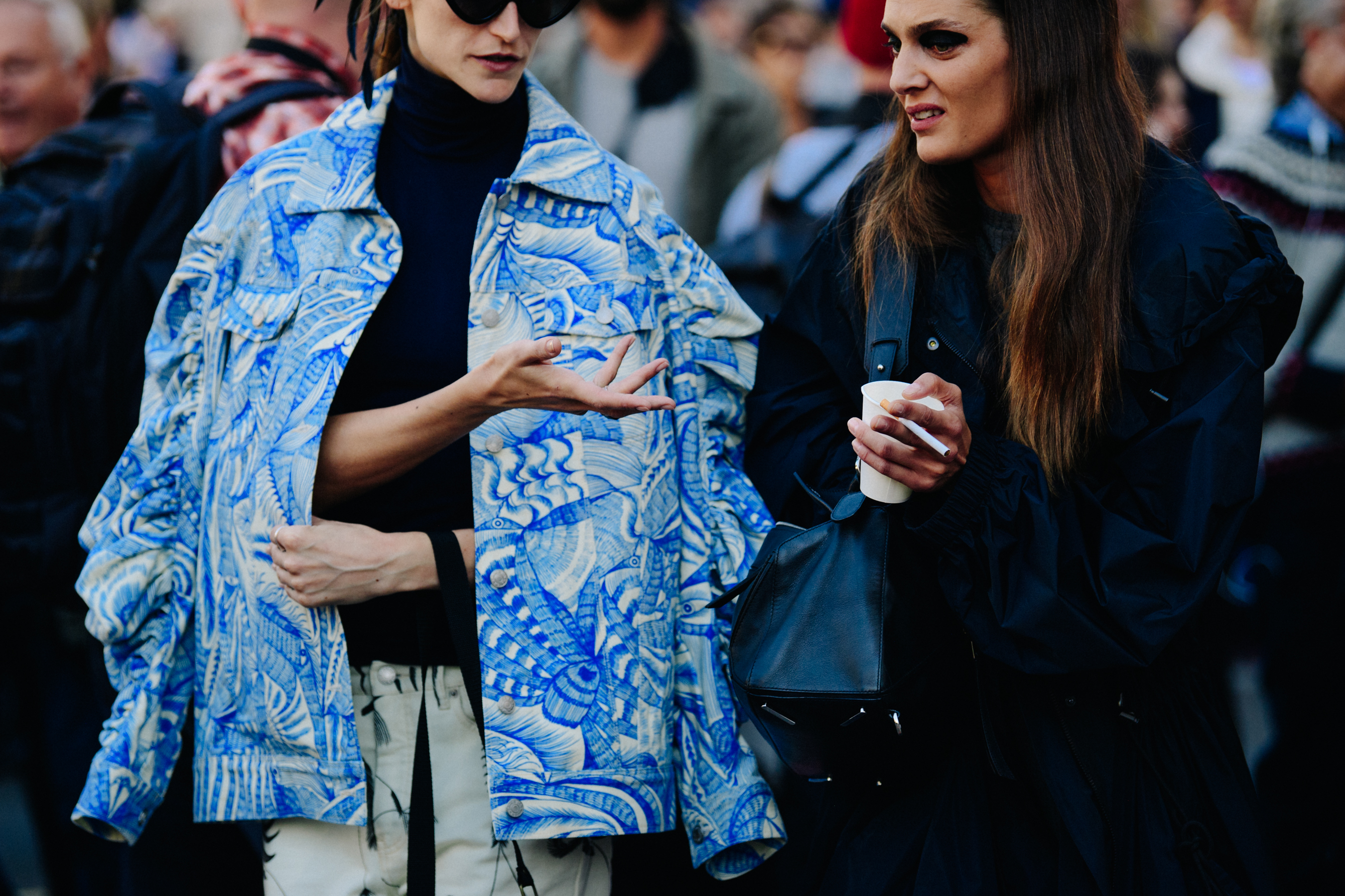 Two women wearing dark blue coats