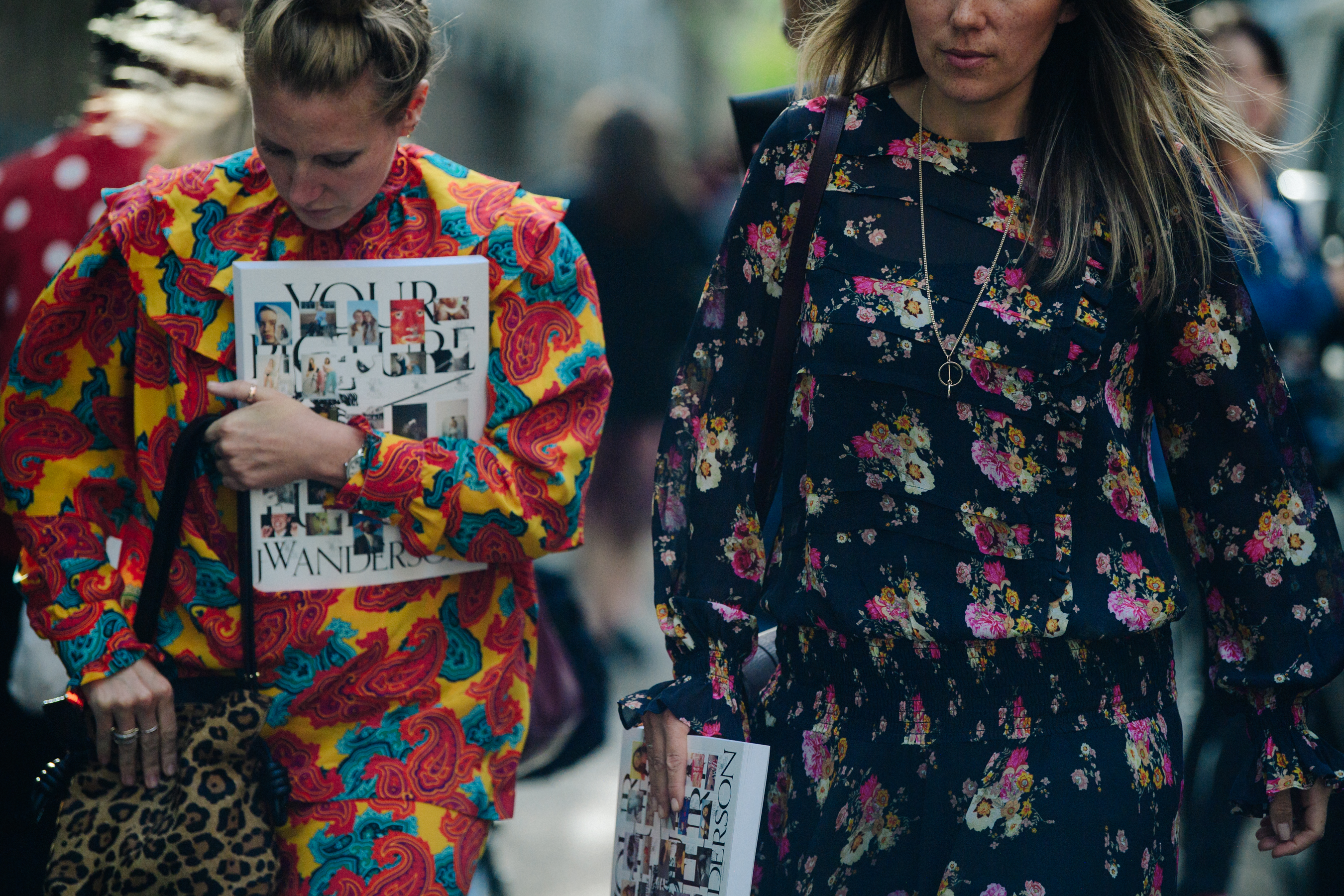 Two women wearing floral dresses
