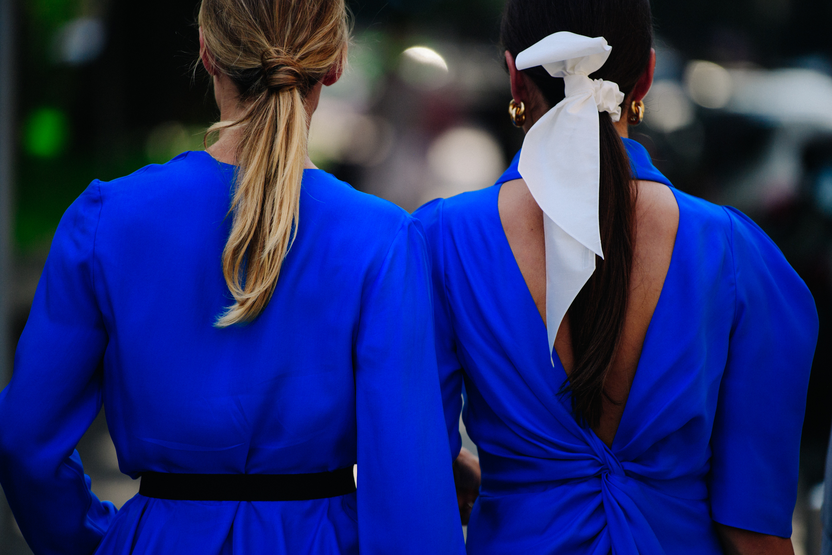 Two women wearing blue dresses
