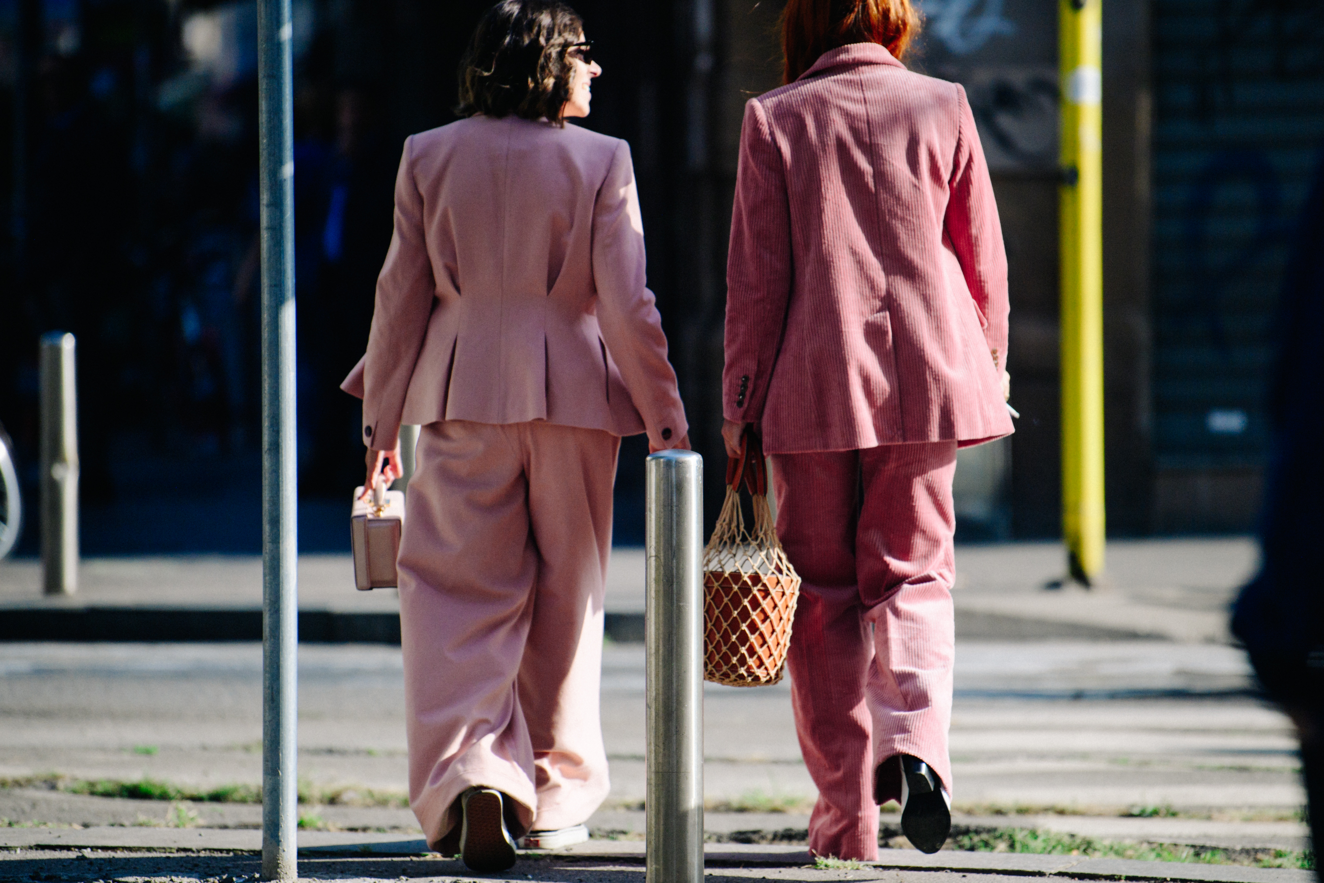 Two women wearing pink suits