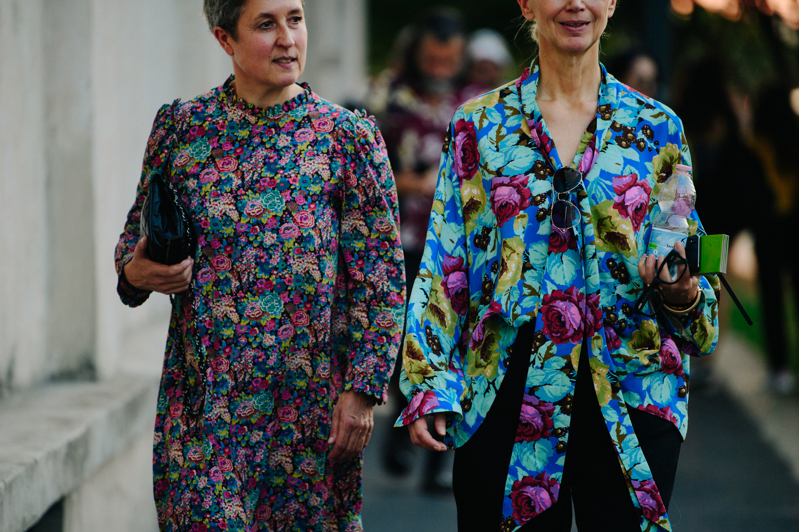 Two women wearing floral dresses