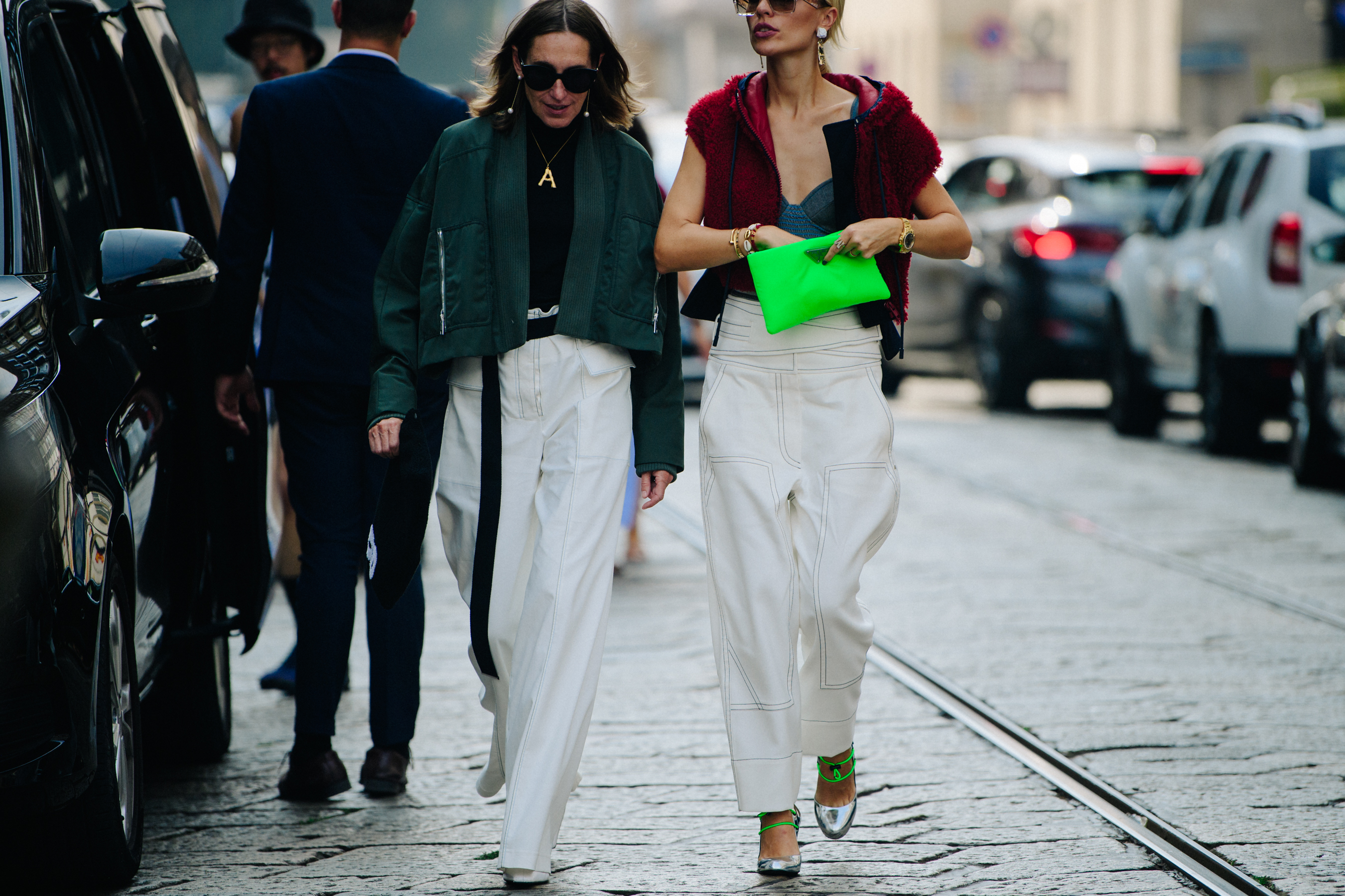 Two women wearing white pants